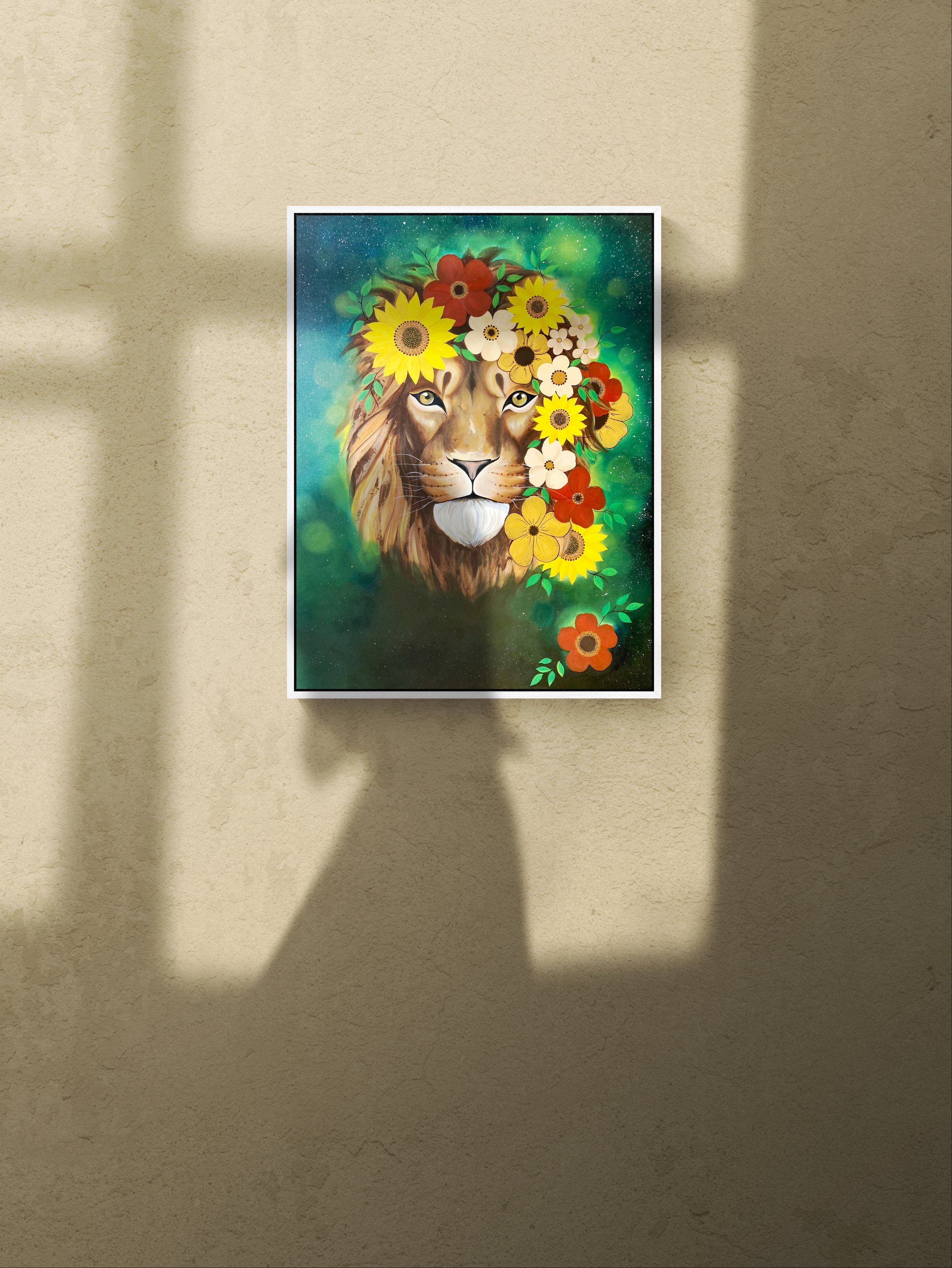 A framed painting of a lion's face with a mane made of colorful flowers, hanging on a beige wall.