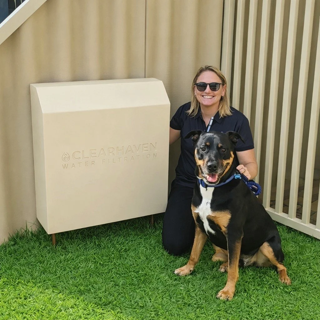 Jade De Joode, founder of ClearHaven Water Filtration, beside a custom powder-coated filtration cover with her dog, representing the inspiration behind her premium whole-home water filtration business in Perth.