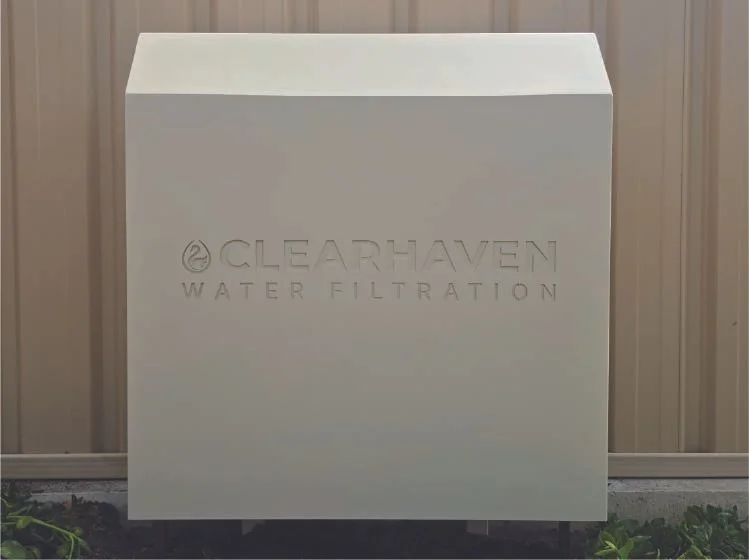 ClearHaven TripleShield whole-home water filtration system with a Classic Cream powder-coated cover, professionally installed against a matching Colorbond fence in Maddington, Perth, featuring a clean, beautifully integrated design.