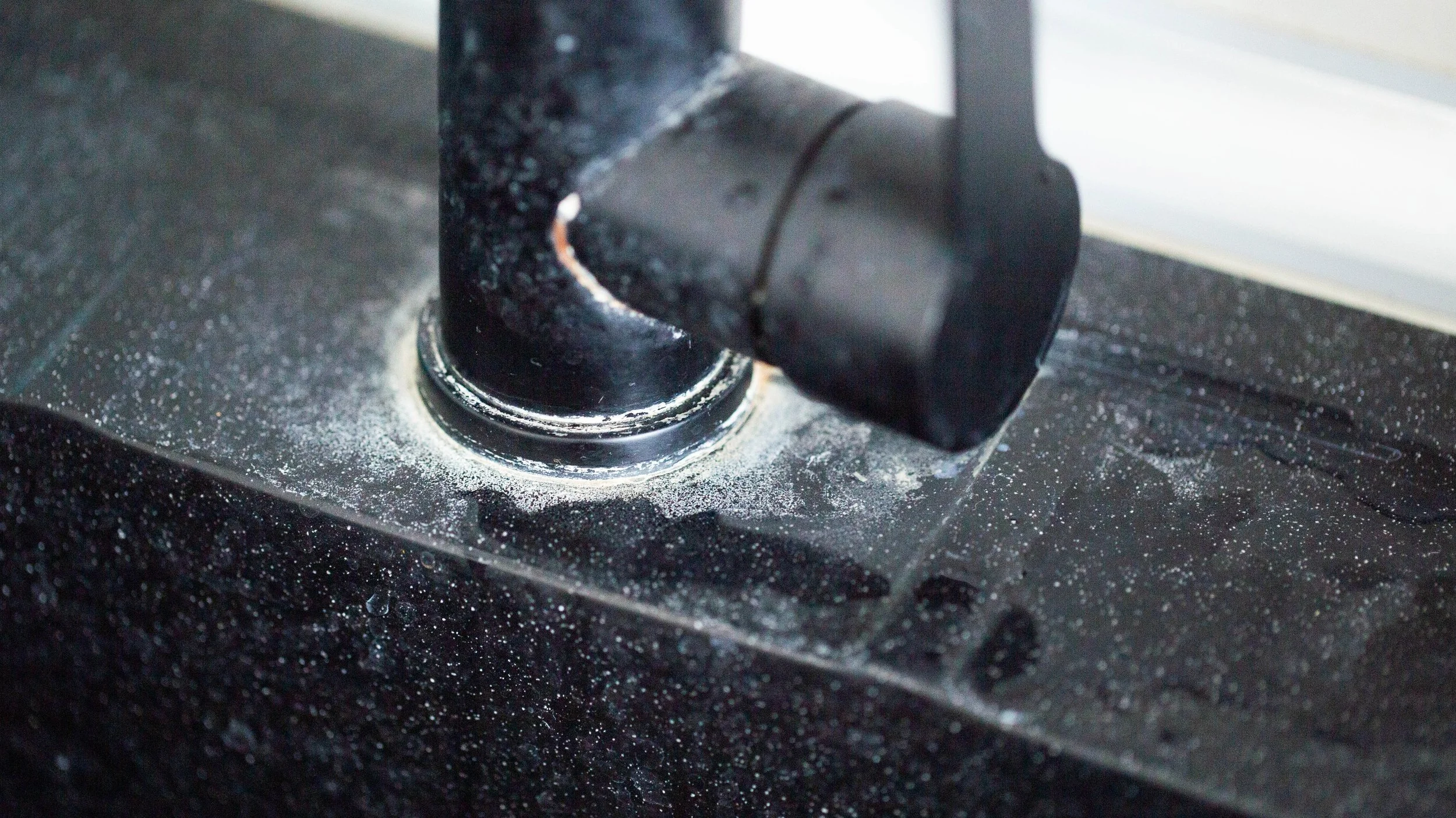 Close-up of hard water scale build-up around a plumbing fitting in a Perth home, showing the effects of calcium and magnesium mineral deposits.