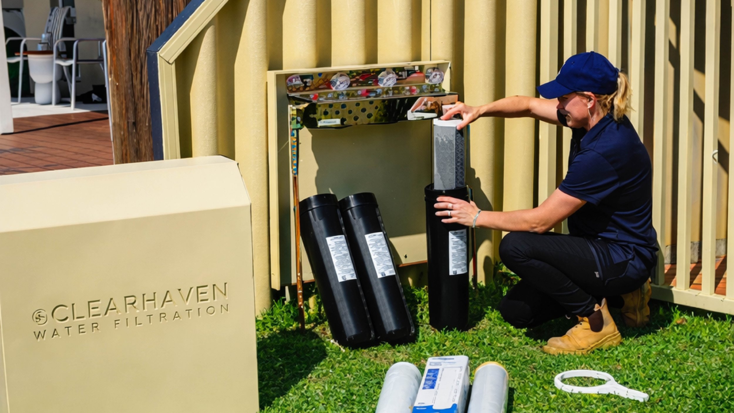 Jade De Joode servicing a ClearHaven whole-home water filtration system, replacing filter cartridges during annual maintenance at a Perth home.