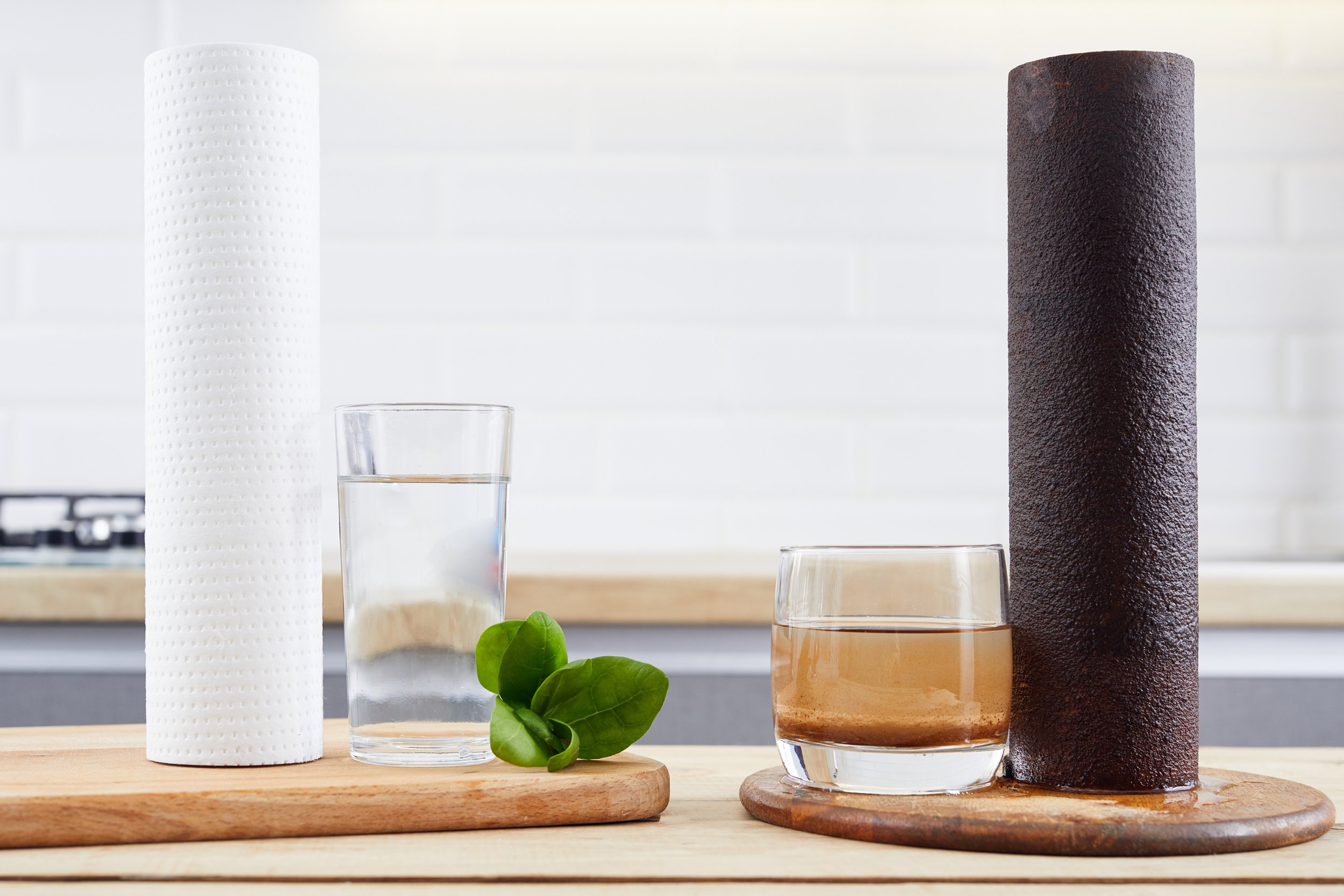 Clean and sediment-filled water filter cartridges beside glasses of filtered and unfiltered water, illustrating how a ClearHaven whole-home water filtration system removes sediment and improves water quality in Perth homes.