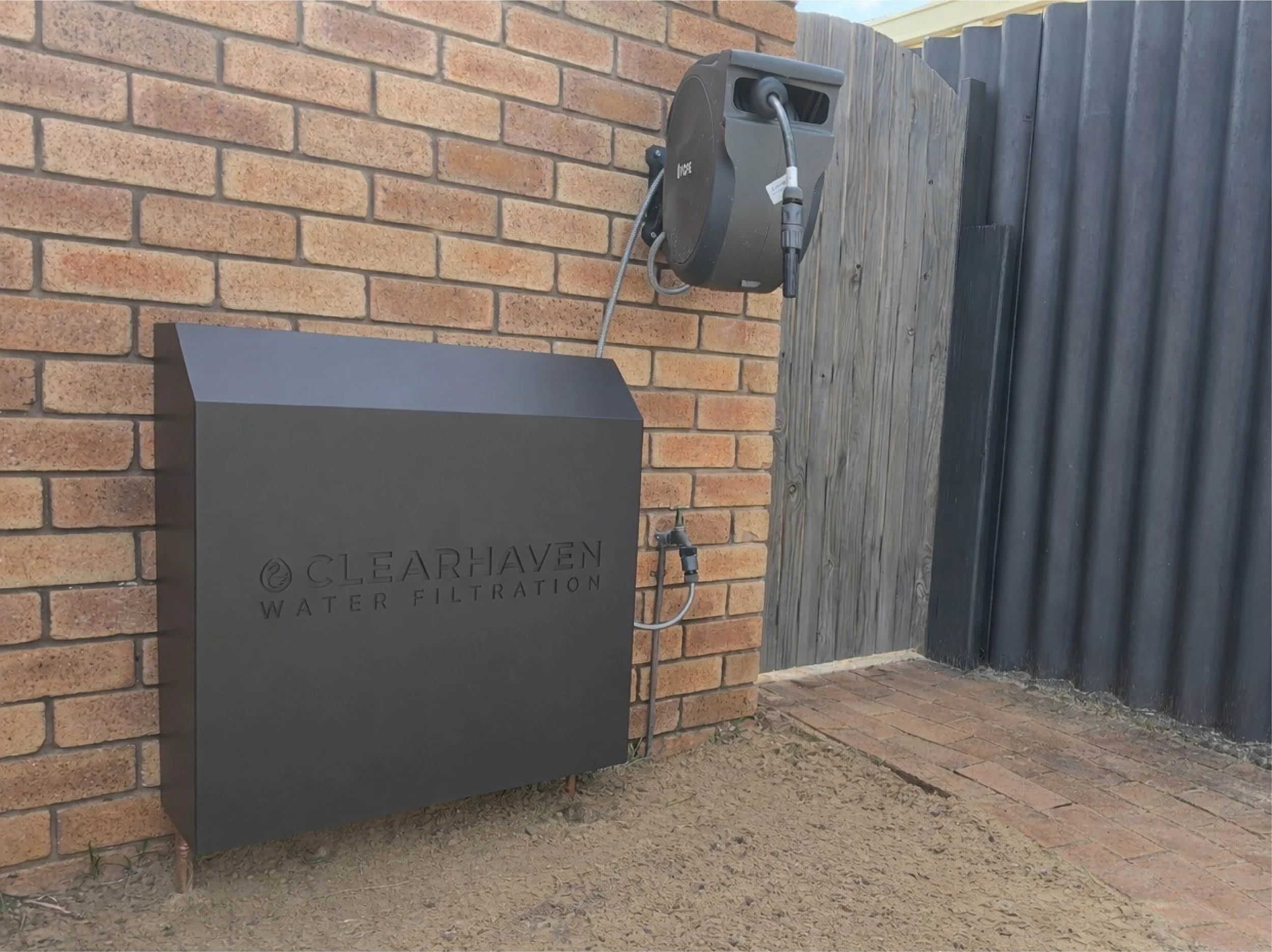 ClearHaven whole-home water filtration system with a custom Monument Colourbond cover professionally installed at a Perth home.