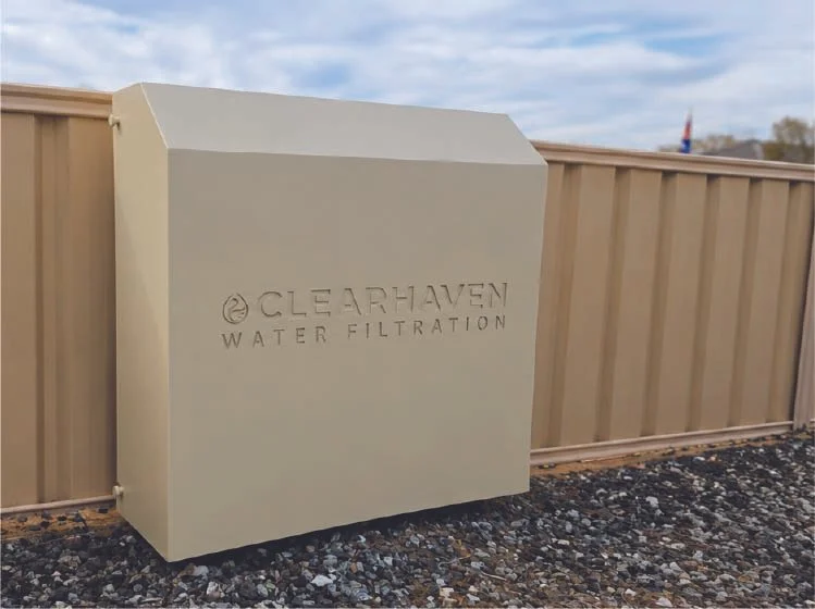 ClearHaven TripleShield whole-home water filtration system with a Classic Cream powder-coated cover, professionally installed against a matching Colorbond fence in Pinjarra, Western Australia, featuring a clean, beautifully integrated design.