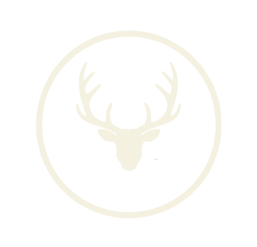A white stag head with antlers inside a white circle on a black background.