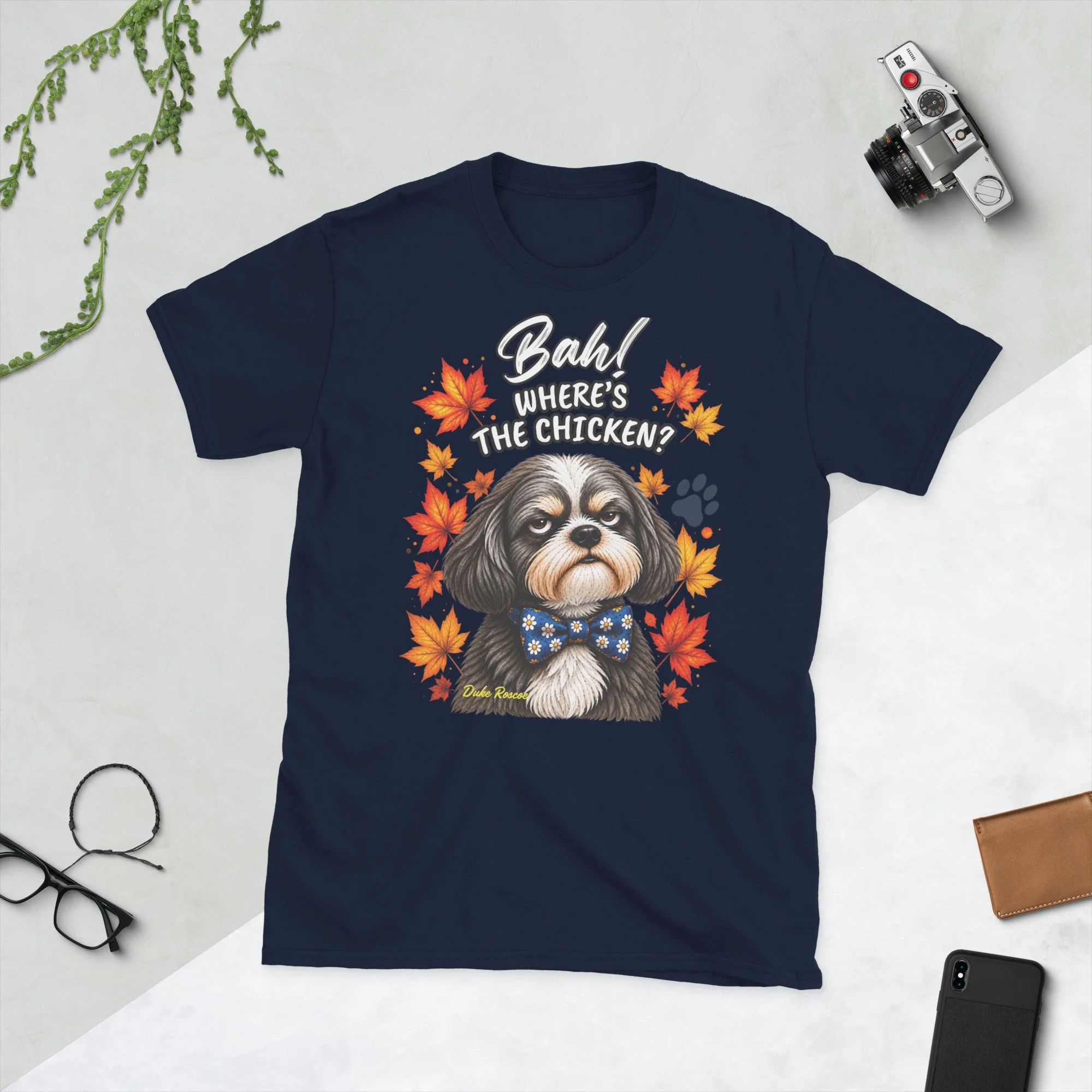 Bah! Where's the Chicken? Duke Roscoe Tee in navy, flat lay: grumpy Shih Tzu in a blue bow tie amid autumn leaves