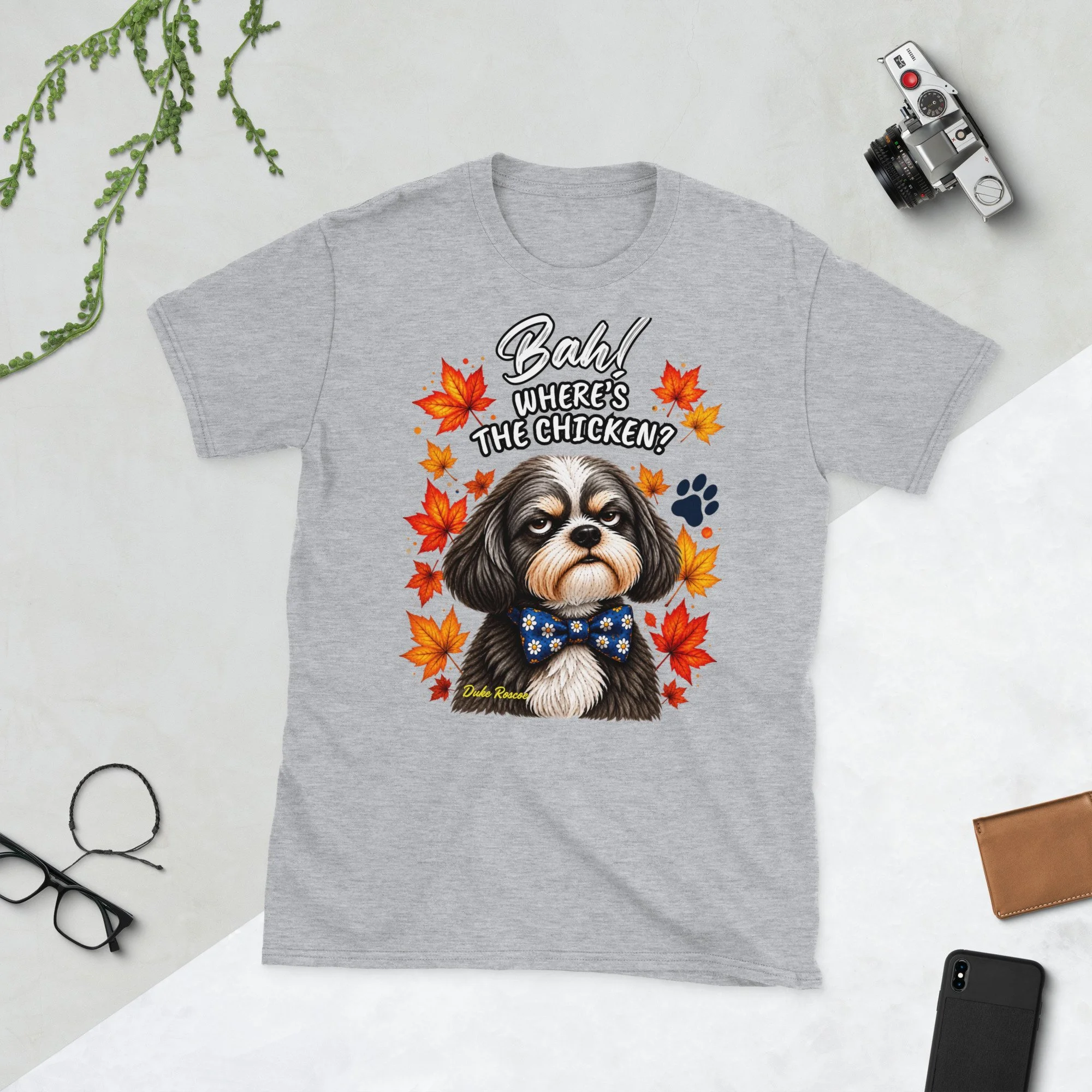 Bah! Where's the Chicken? Duke Roscoe Tee in sport grey, flat lay: grumpy Shih Tzu in a blue bow tie amid autumn leaves