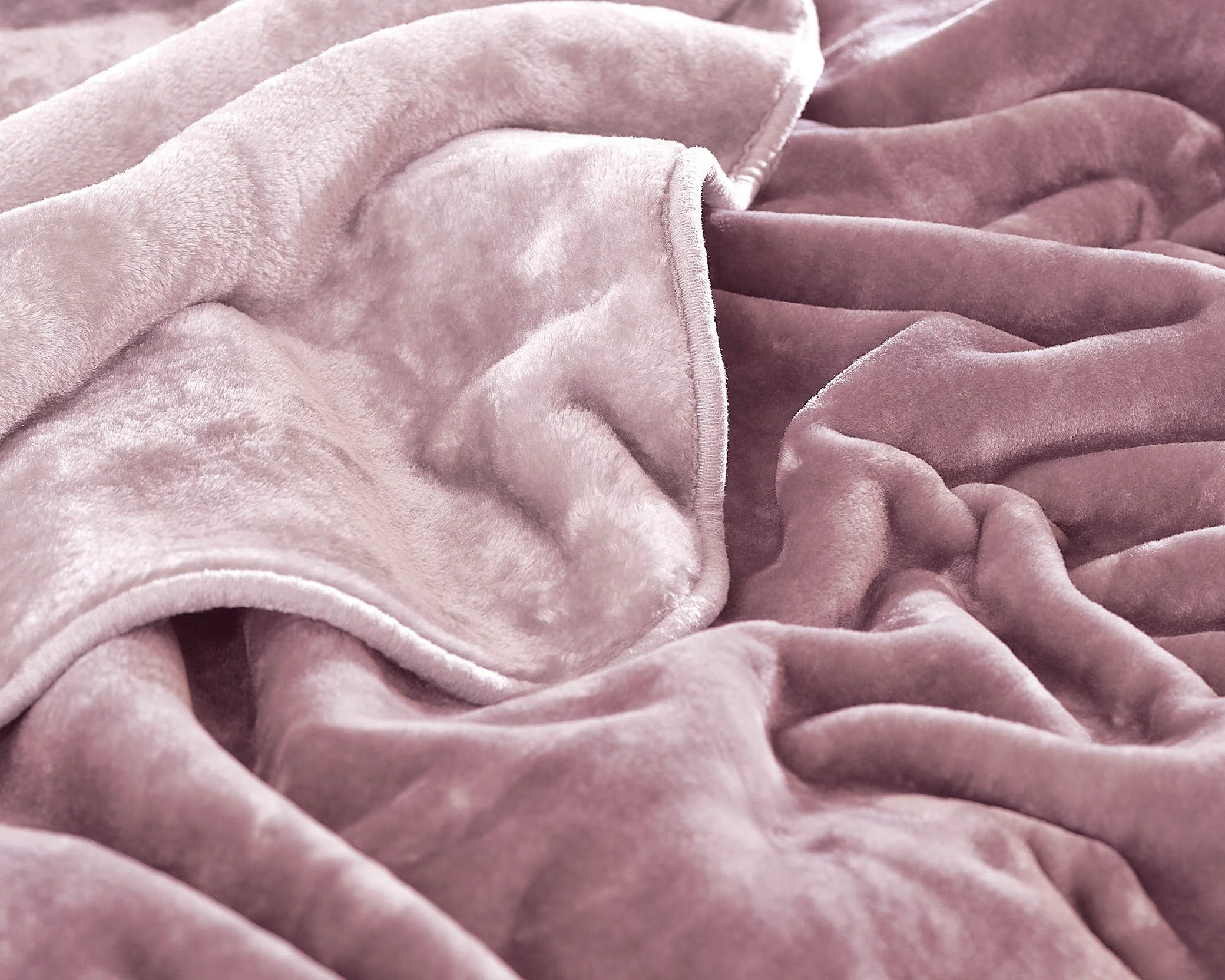 Close-up image of pink velvet fabric with soft folds and texture.