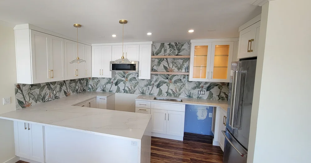 Botanical-pattern kitchen backsplash beneath white cabinets and open wood shelves