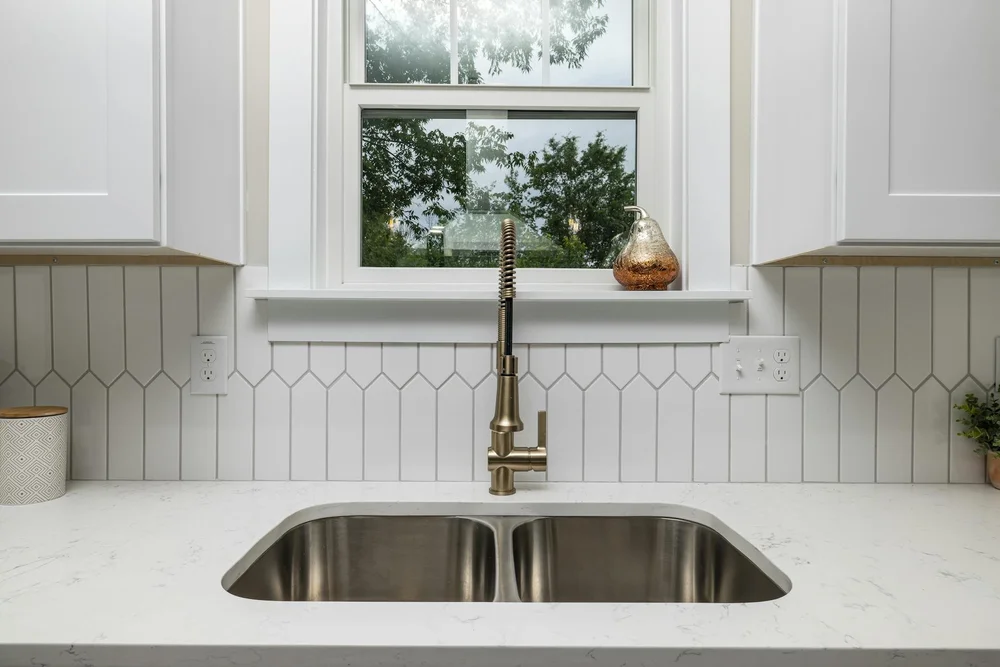 White picket tile backsplash around a kitchen window and sink