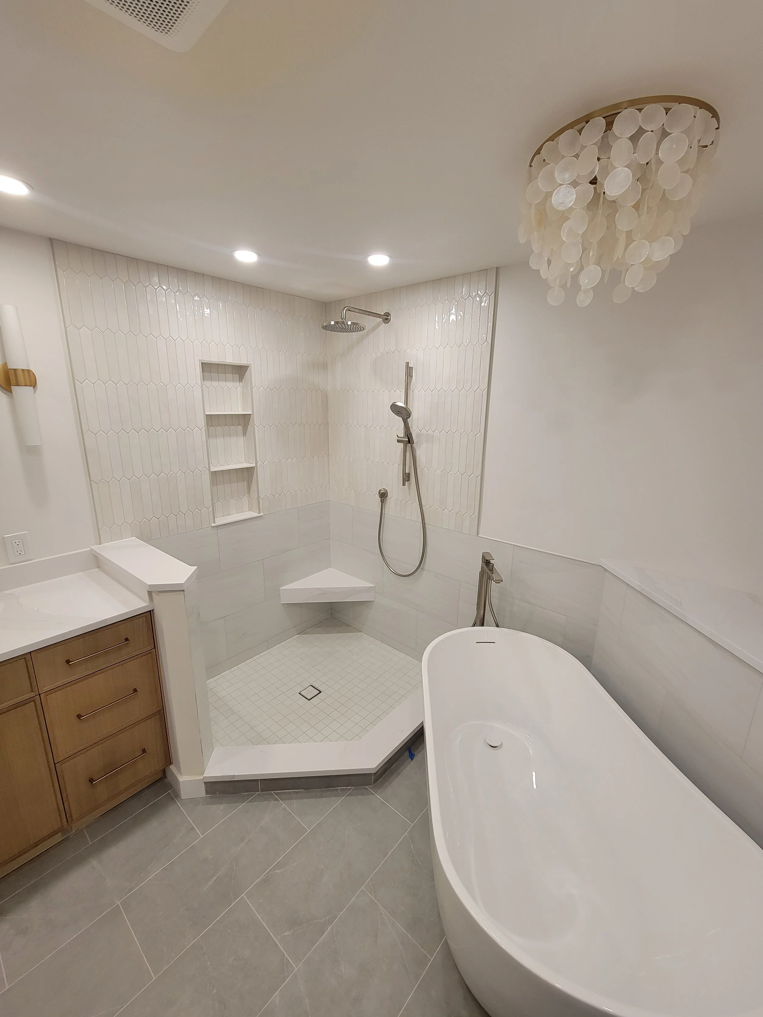 Modern bathroom with a walk-in shower, a freestanding bathtub, a wooden vanity, and a ceiling chandelier.
