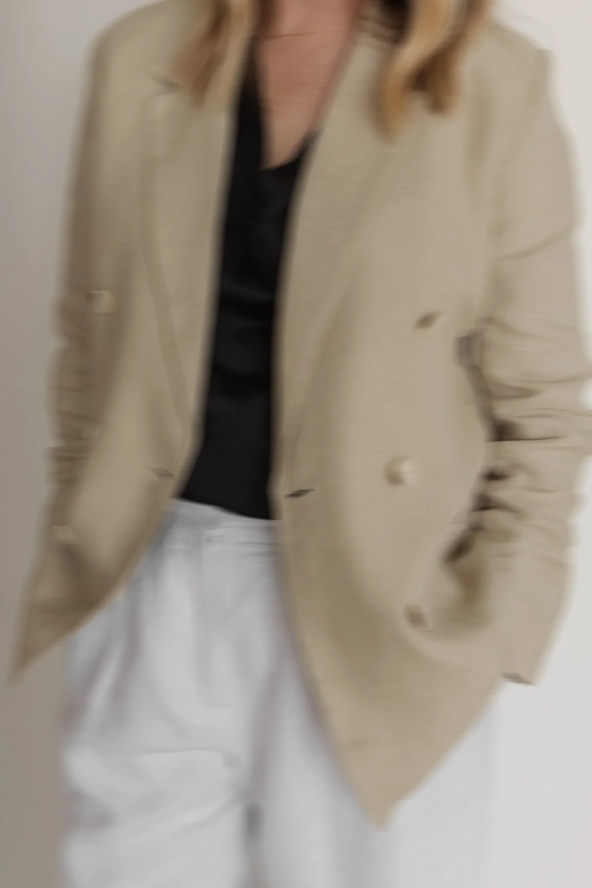 Hayley wearing a tan blazer and white trousers