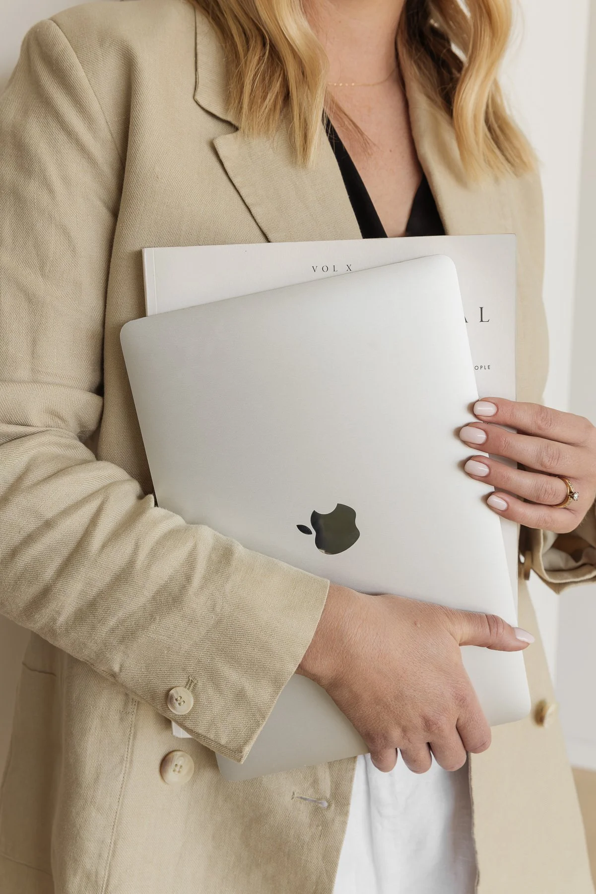 Close-up of a woman holding a MacBook laptop