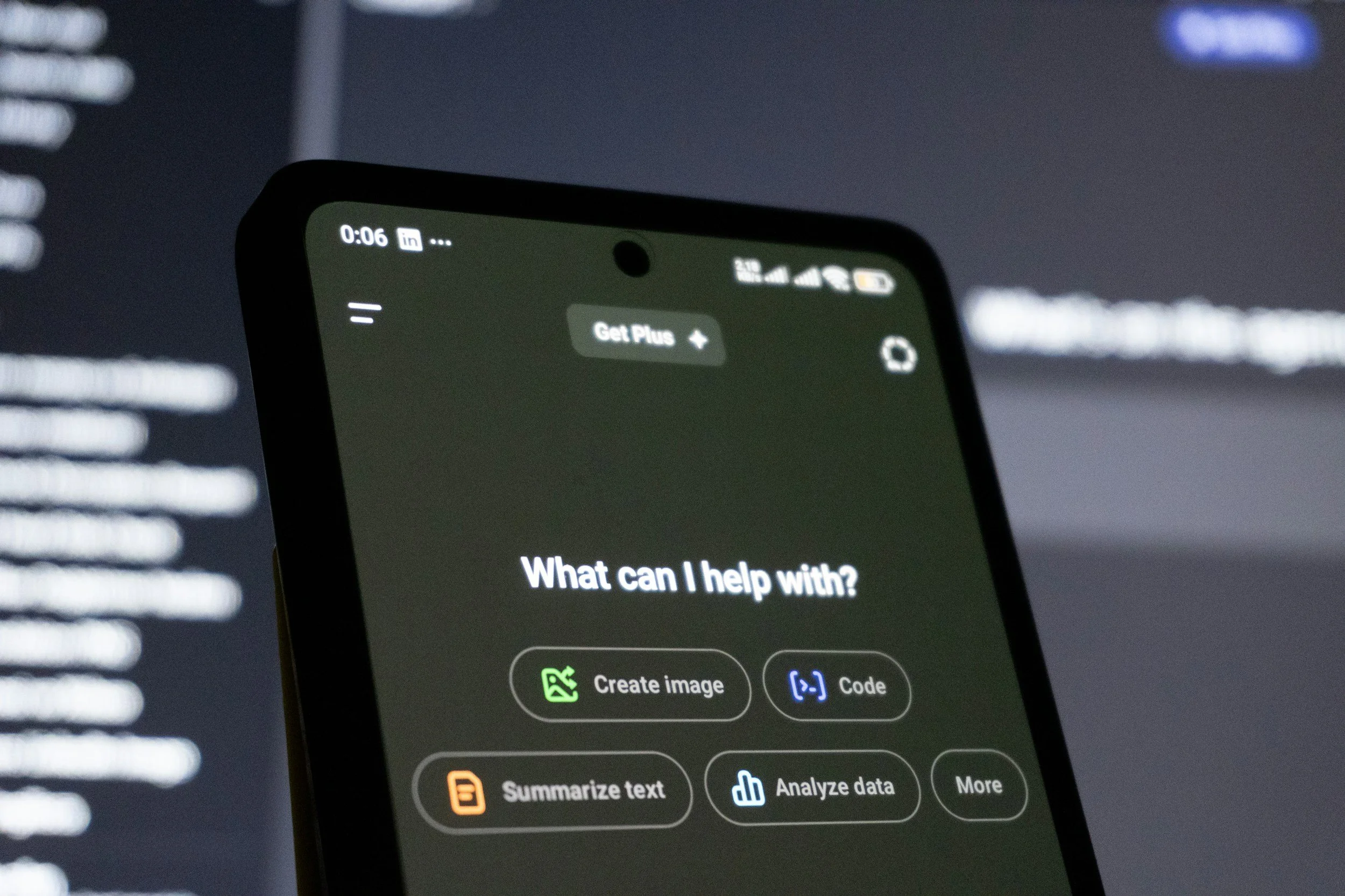 Close-up of a smartphone screen showing app options such as 'Create image,' 'Code,' 'Summarize text,' and 'Analyze data,' with a blurred background.