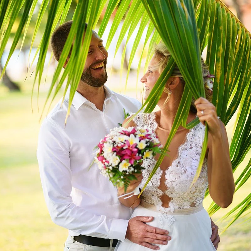 Tropical palm tree leaves with newlyweds