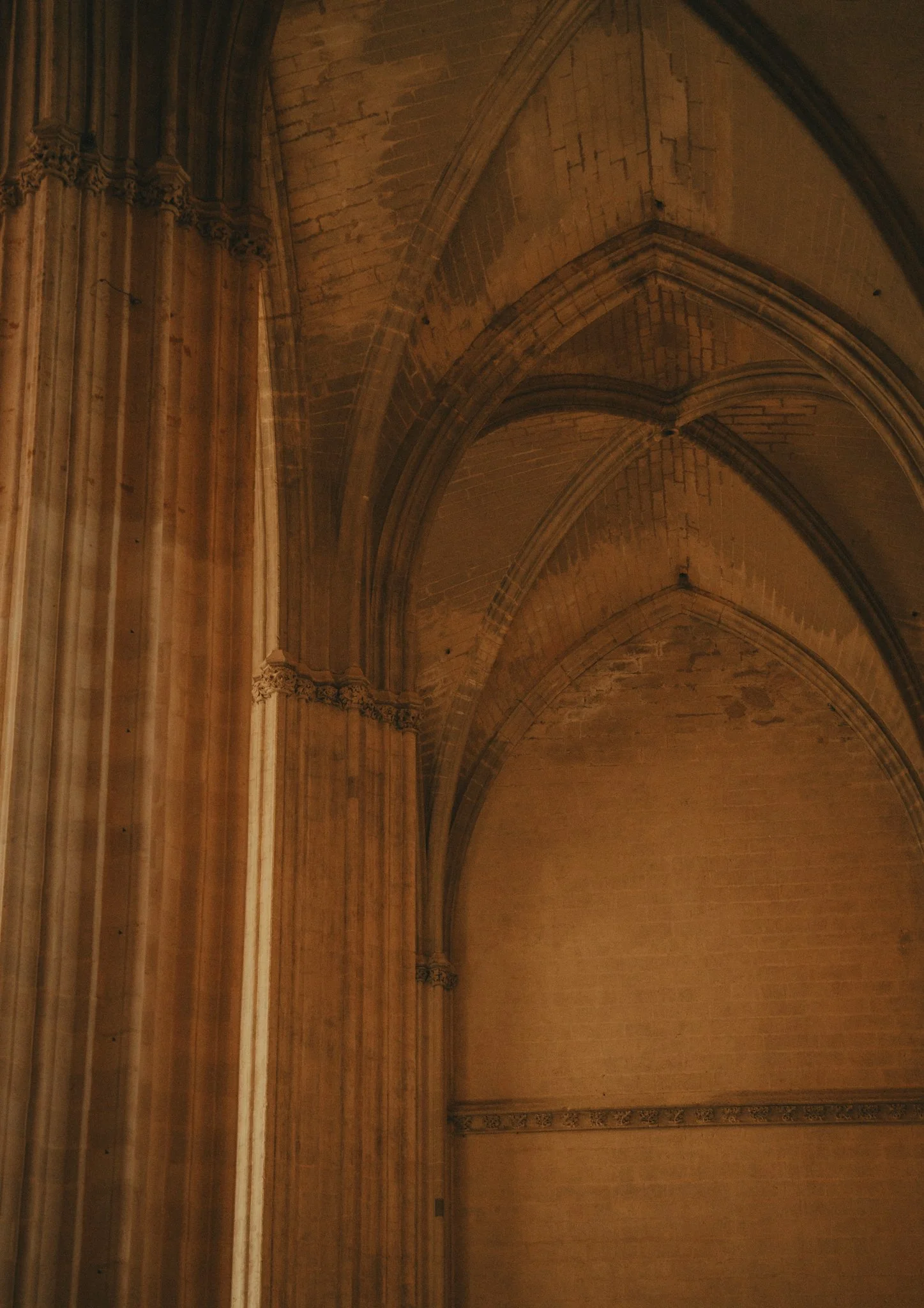 Interior of a gothic cathedral showing high vaulted ceilings, pointed arches, and ornate columns.