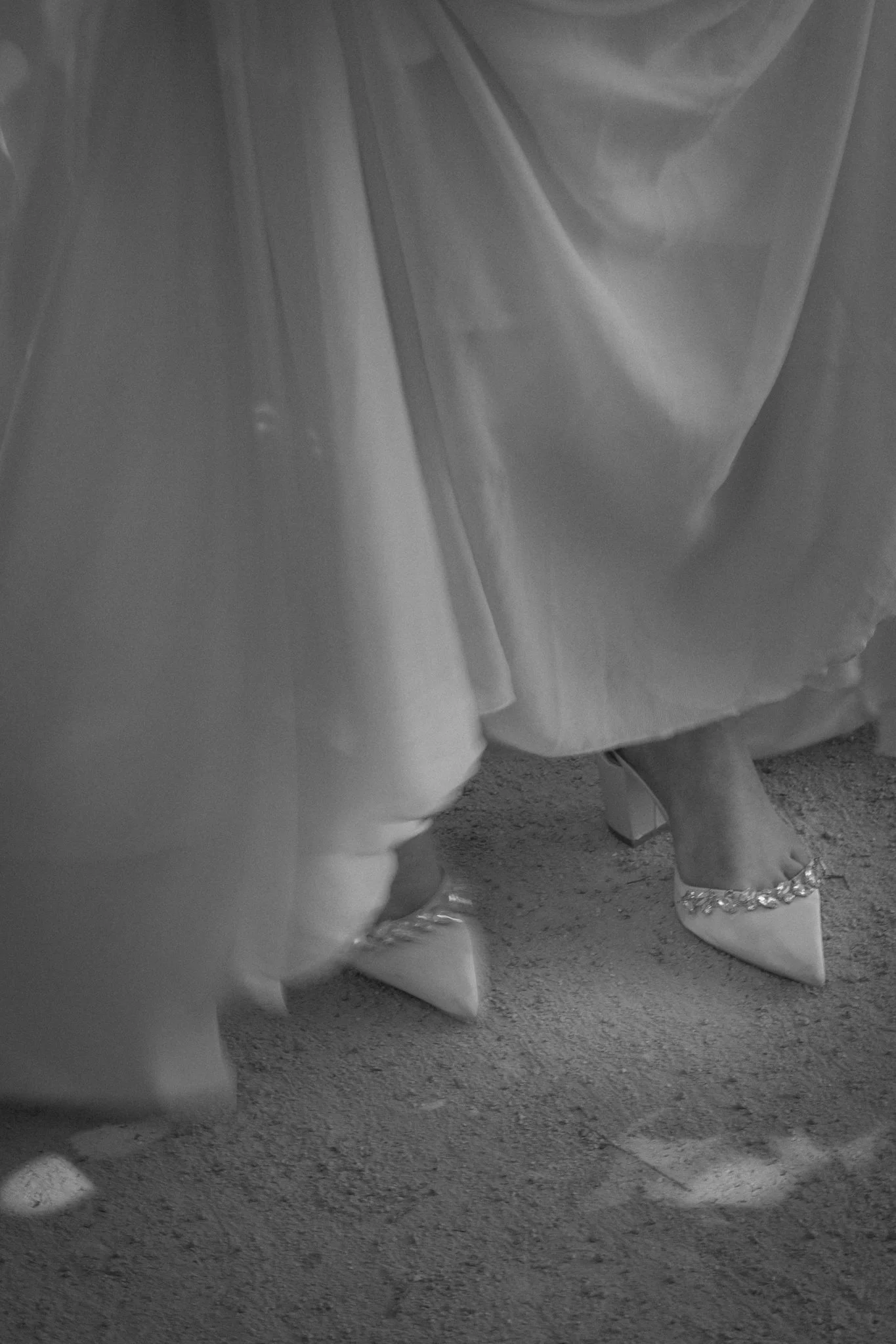 Close-up of a group of women wearing high heels with ankle straps and embellished details, sitting together.