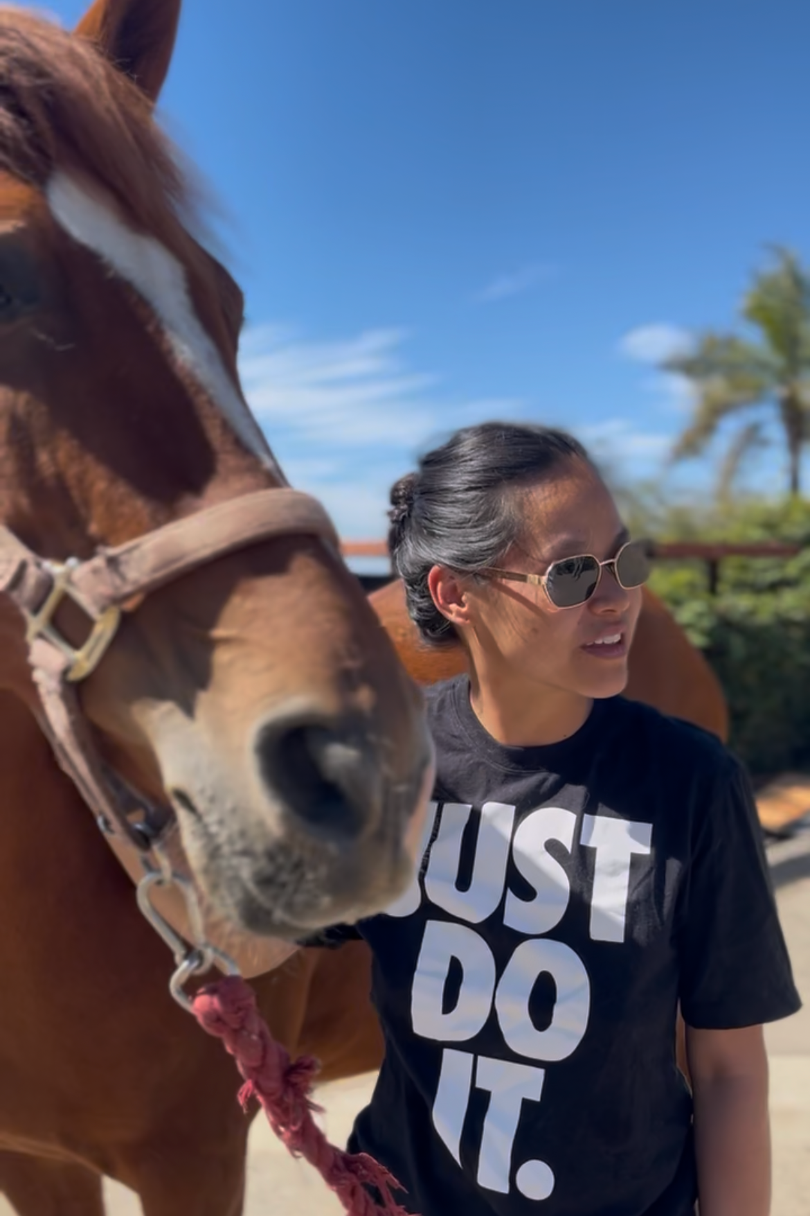 A guest at the Meditation with Horses community event spending time near a horse in the arena.
