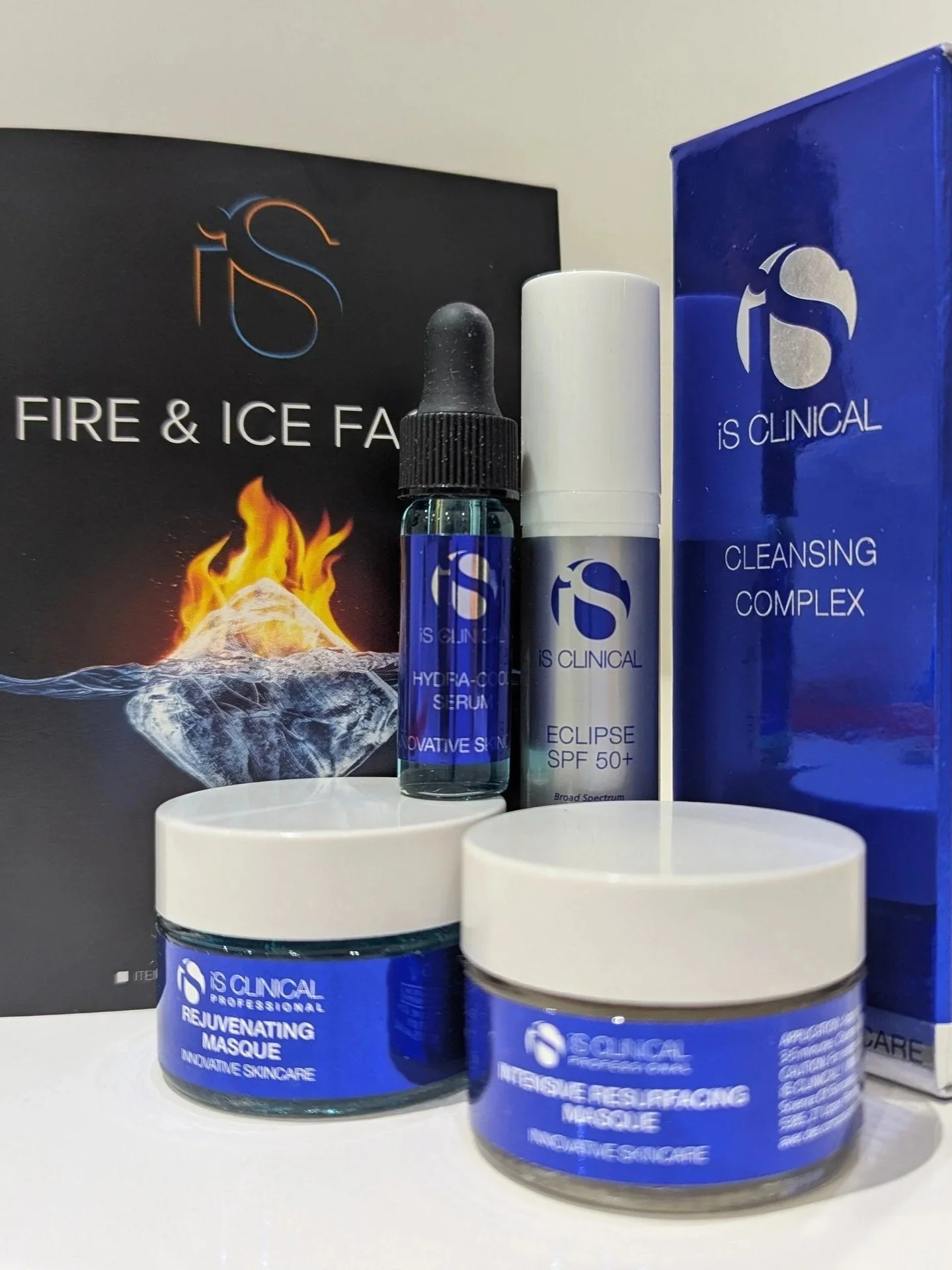 Collection of skincare products including creams, serums, and a box, from IS Clinical, with packaging featuring a blue and white color scheme and the IS Clinical logo.