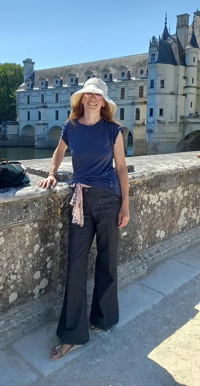 Victoria Ellis standing beside a stone bridge in castle gardens.