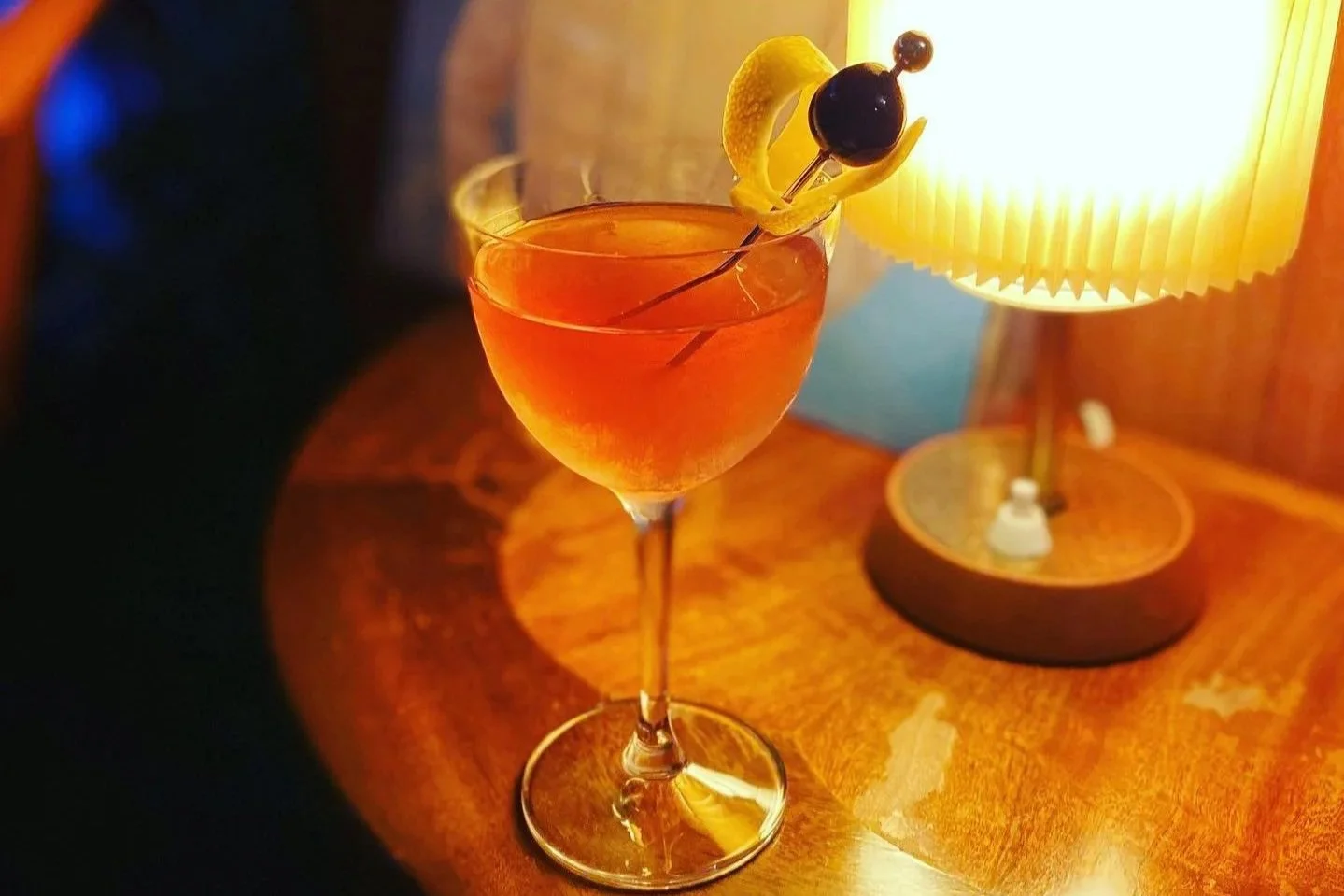 A cocktail on a side table with warm lighting at Side B vinyl bar, Blackheath