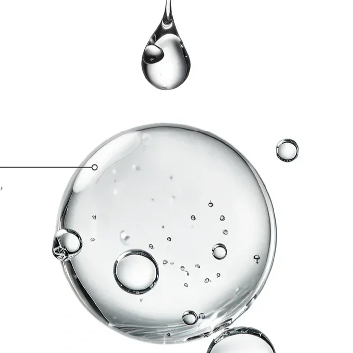 Close-up of clear liquid bubbles on a white background, with a large bubble and a drop of liquid above.