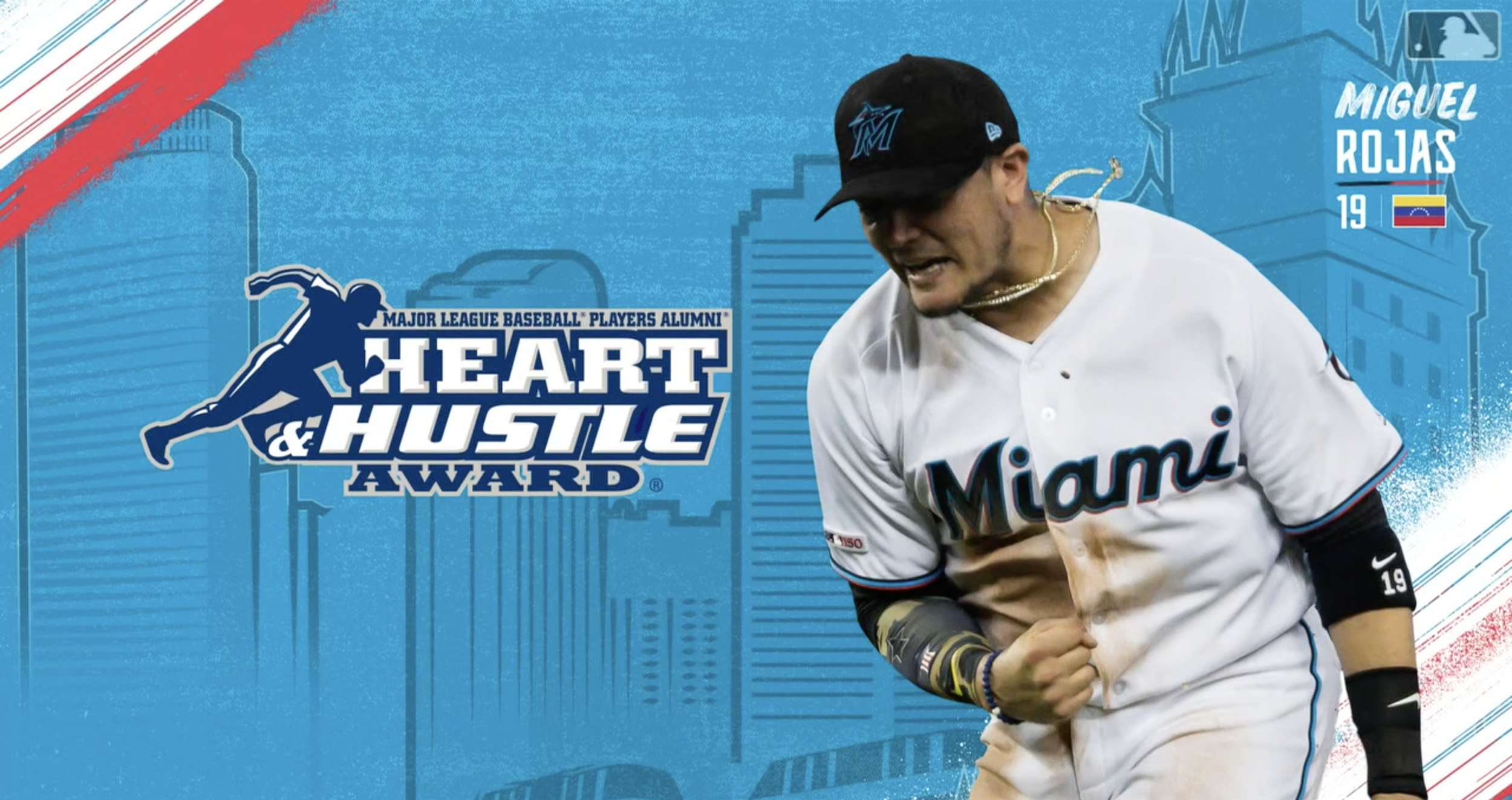 Miguel Rojas of the Miami Marlins during a Major League Baseball Heart & Hustle Award event, wearing a white Miami jersey and a black cap.
