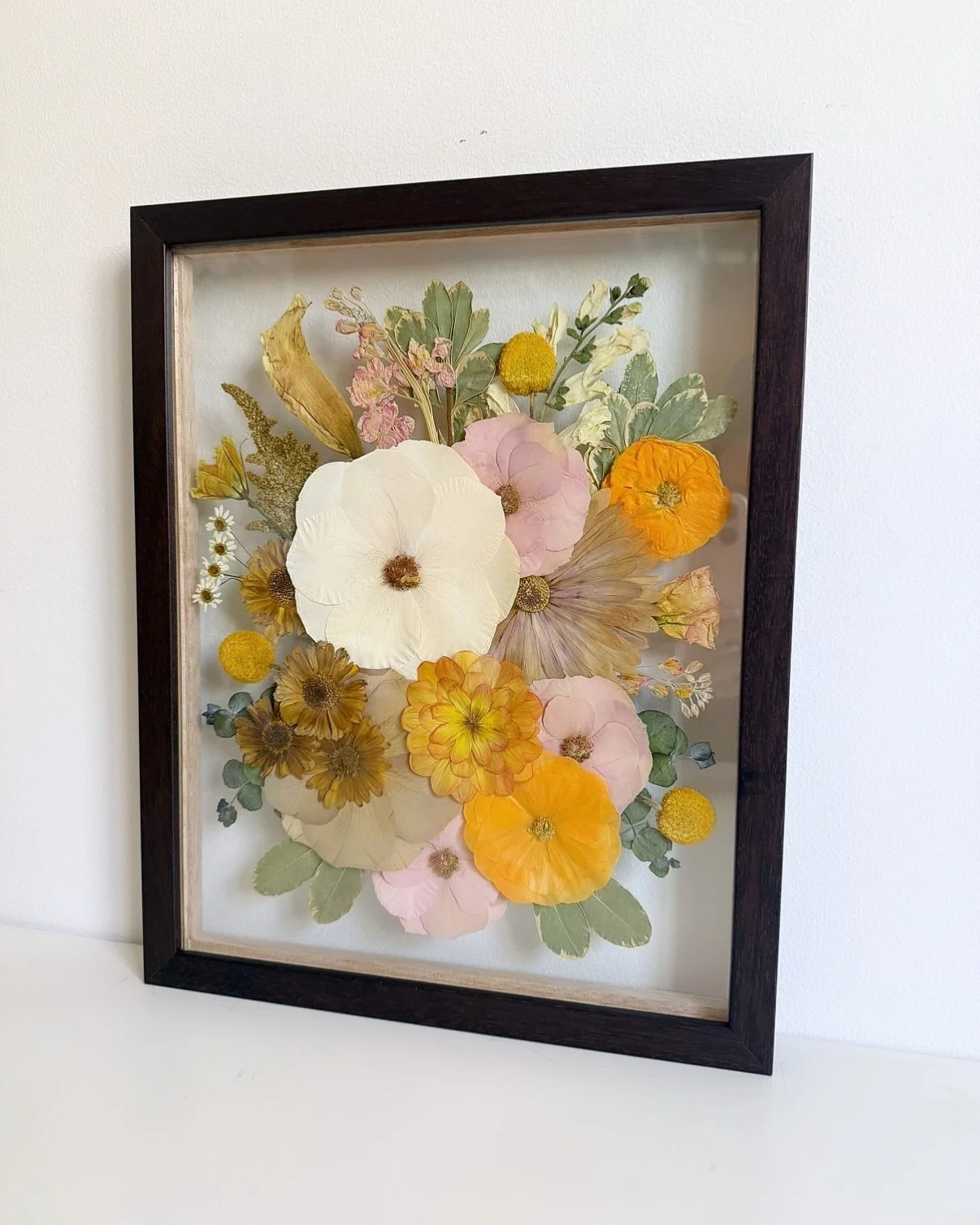 a beautiful frame with pops of orange for Kelsie🧡 more requests for portrait orientation, please!

12x16&rdquo; floating glass frame in dark wood📸

#bouquetpreservation #2026wedding #pressedflowers #bridalbouquet #flowerpreservation