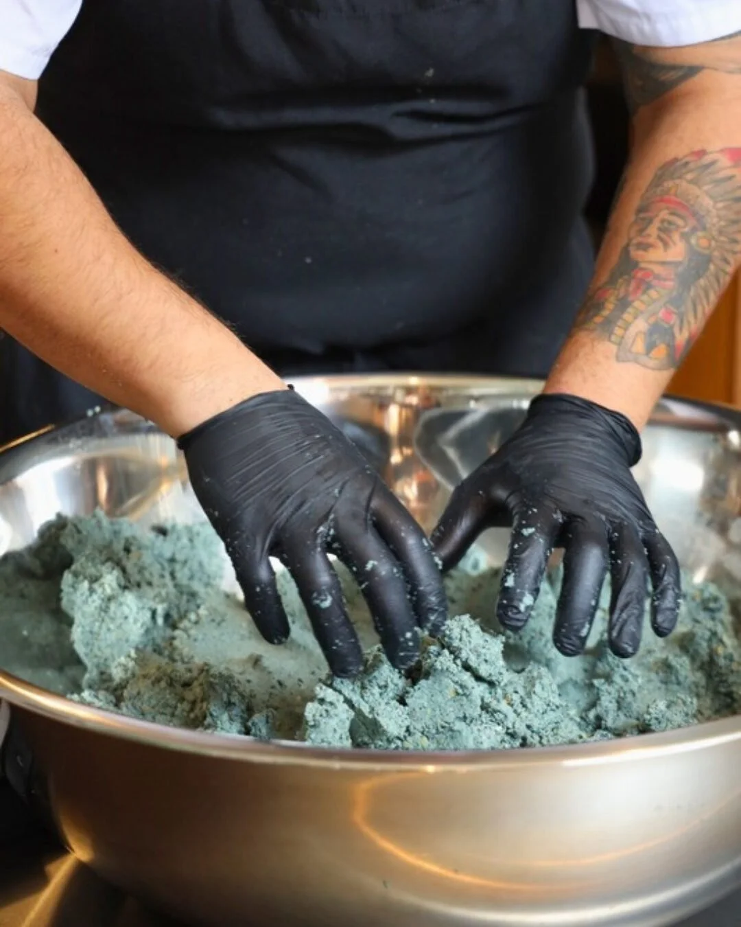 Hands pressing blue corn masa for handmade tortillas at Amasa Mexican Kitchen