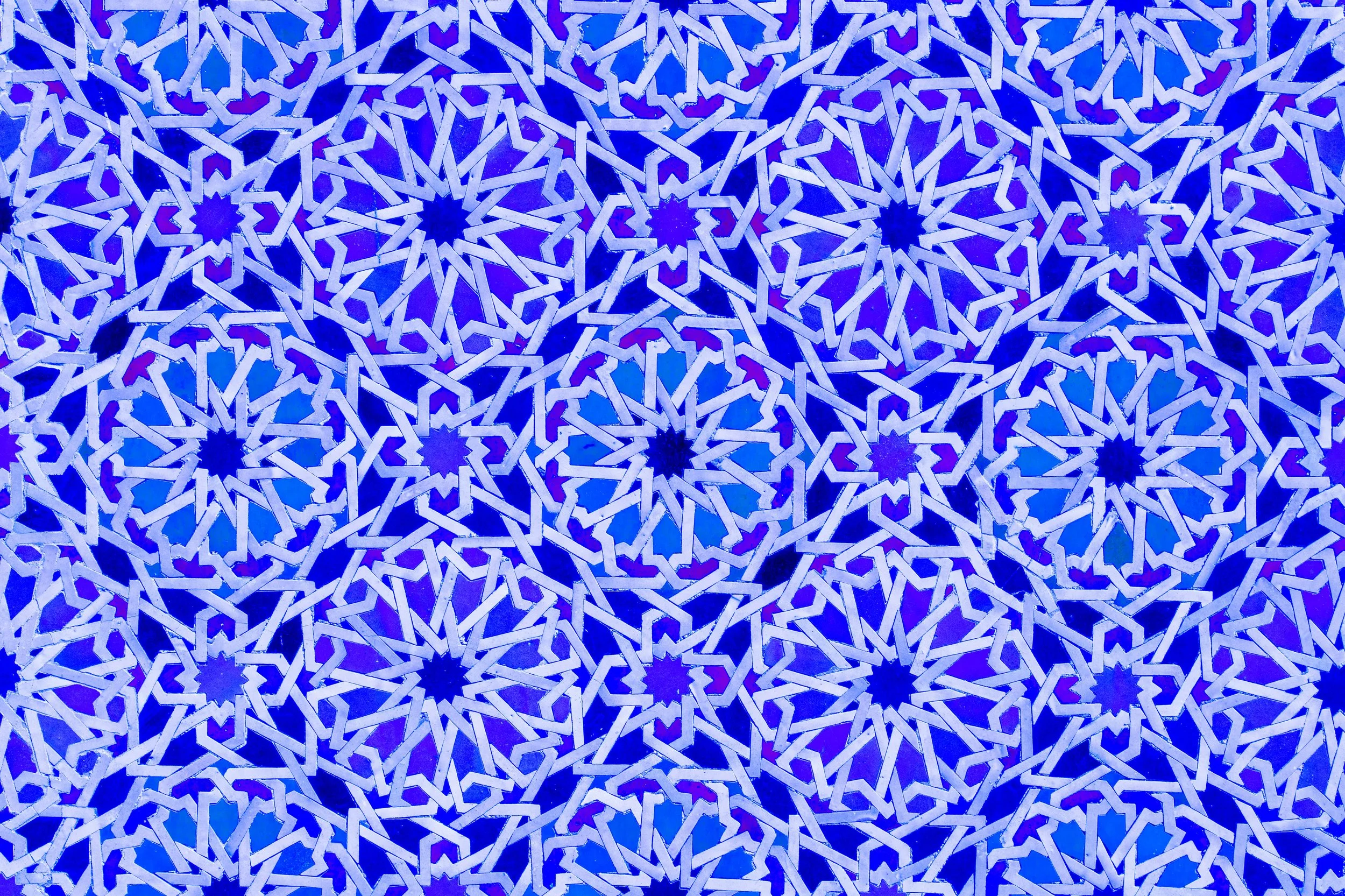 Intricate blue and white geometric mosaic pattern with star shapes and interlocking lines.