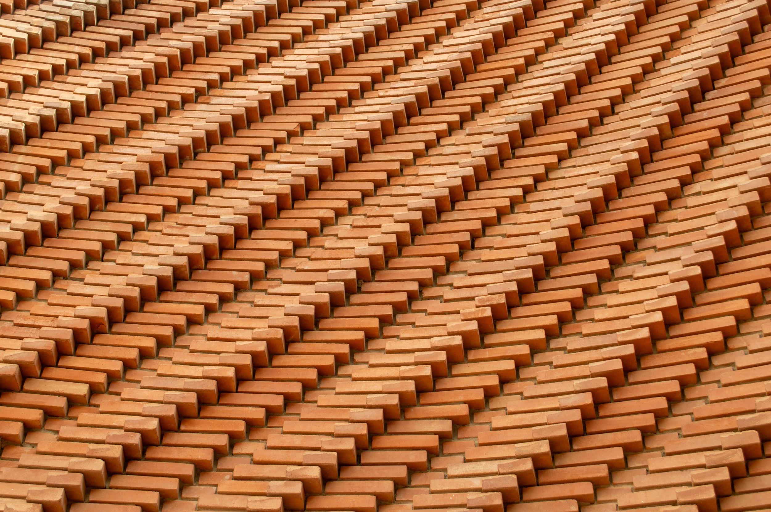 Close-up view of a roof covered with evenly arranged red clay tiles.