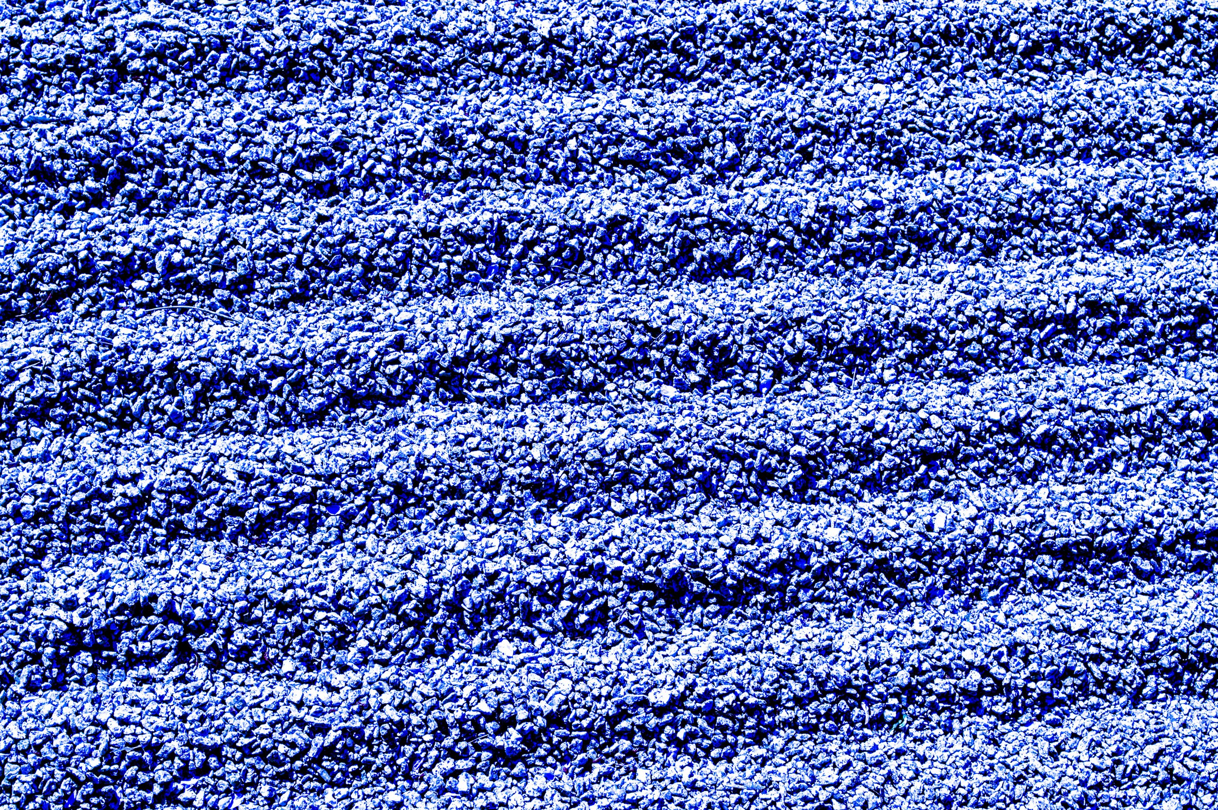 Close-up of a bed of small stones or gravel, with blue lighting creating a dramatic effect.