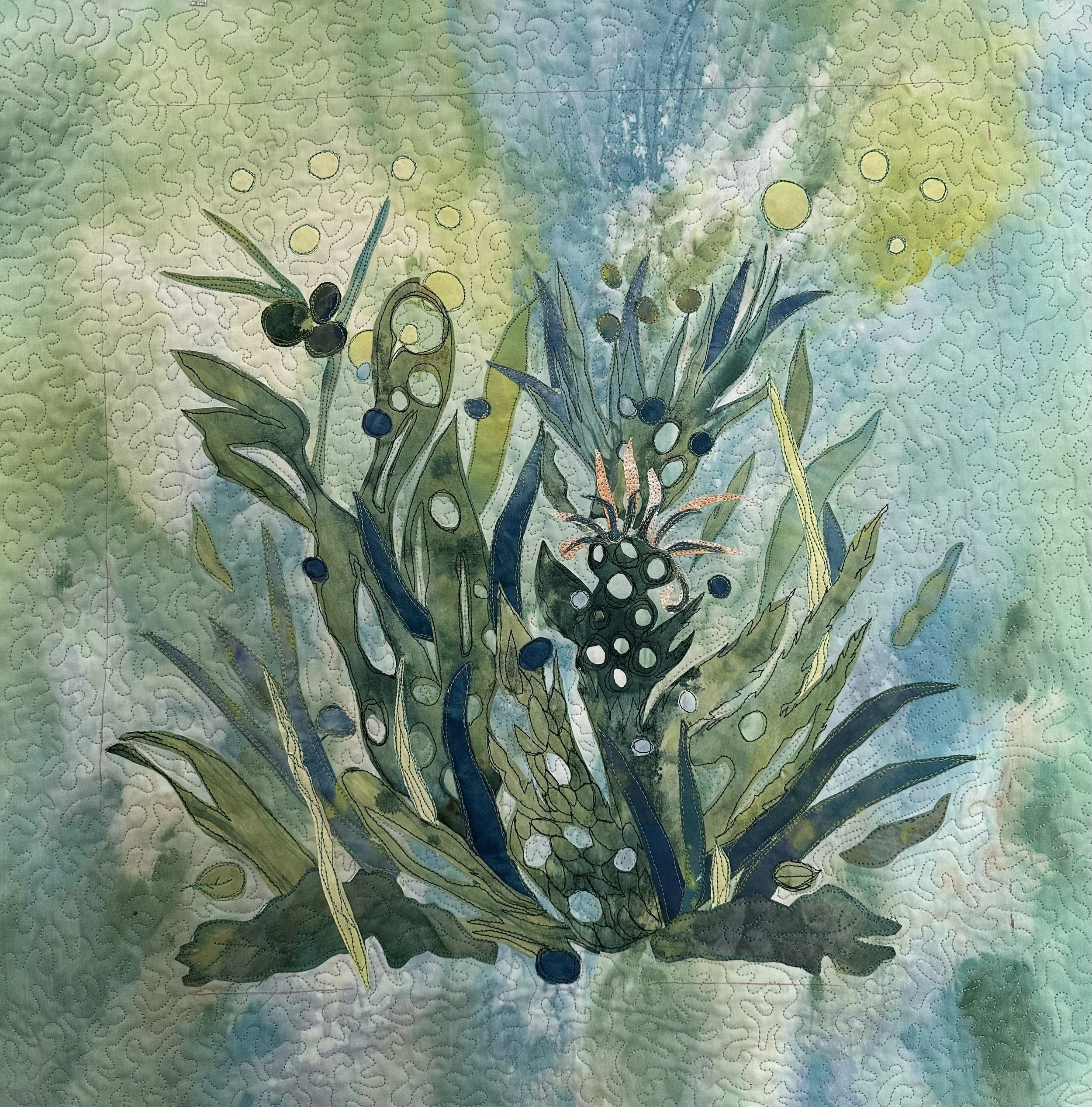 A detailed pattern of fiber art painted botanical illustration featuring leaves, berries, and grasses on a painted fabric background with a blend of green, blue, and yellow hues.