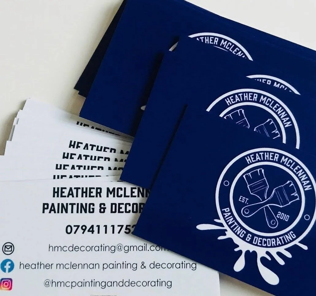 Business cards and flyers for Heather McLennan Painting & Decorating, featuring a blue card with white logo of paint brushes crossed and the company name, established in 2010, along with contact details including email, phone number, and social media handles.
