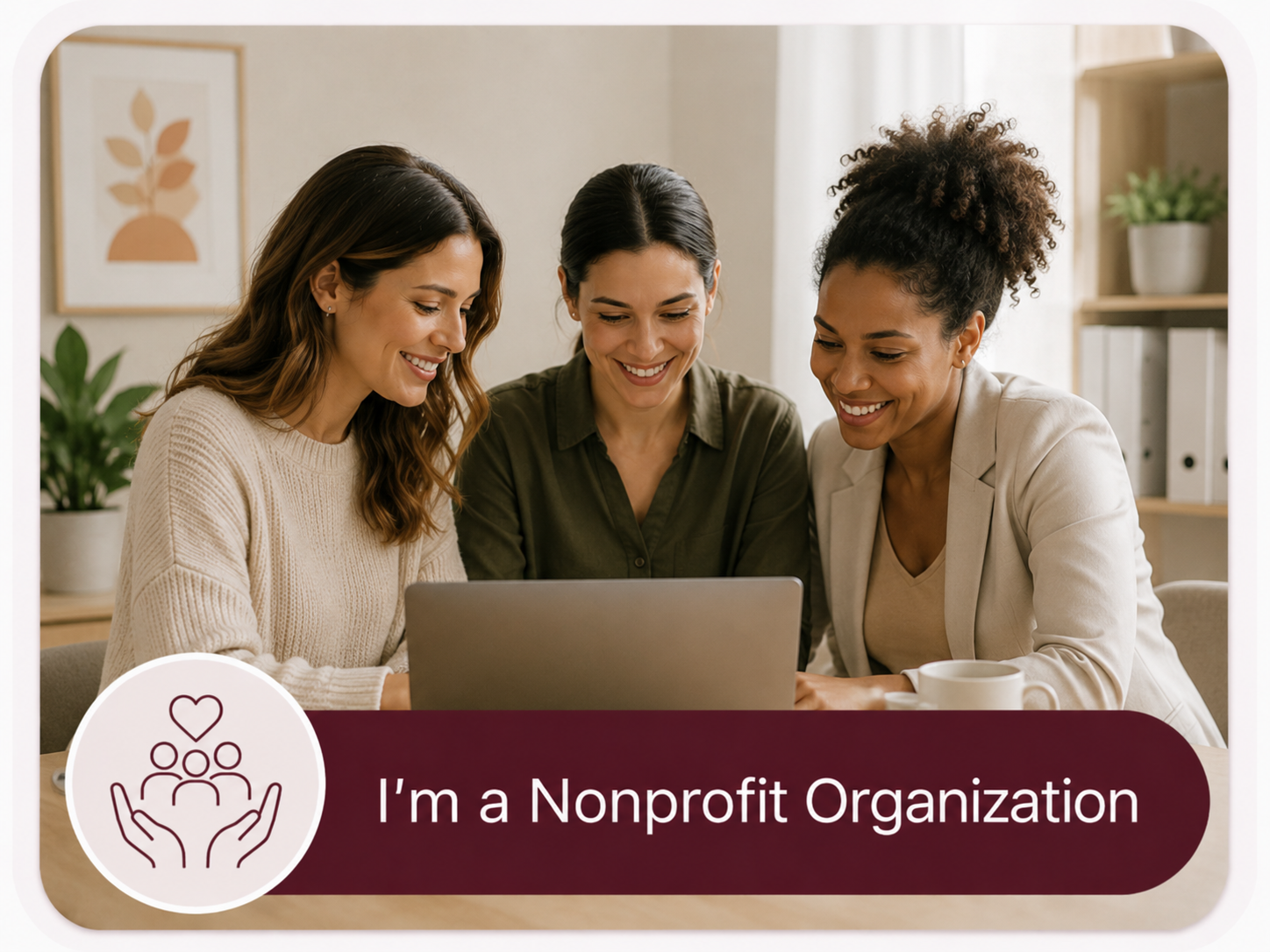 Three women are sitting together at a table, looking at a laptop and smiling. The image includes a badge with a heart and three people icon, and text that reads "I'm a Nonprofit Organization."