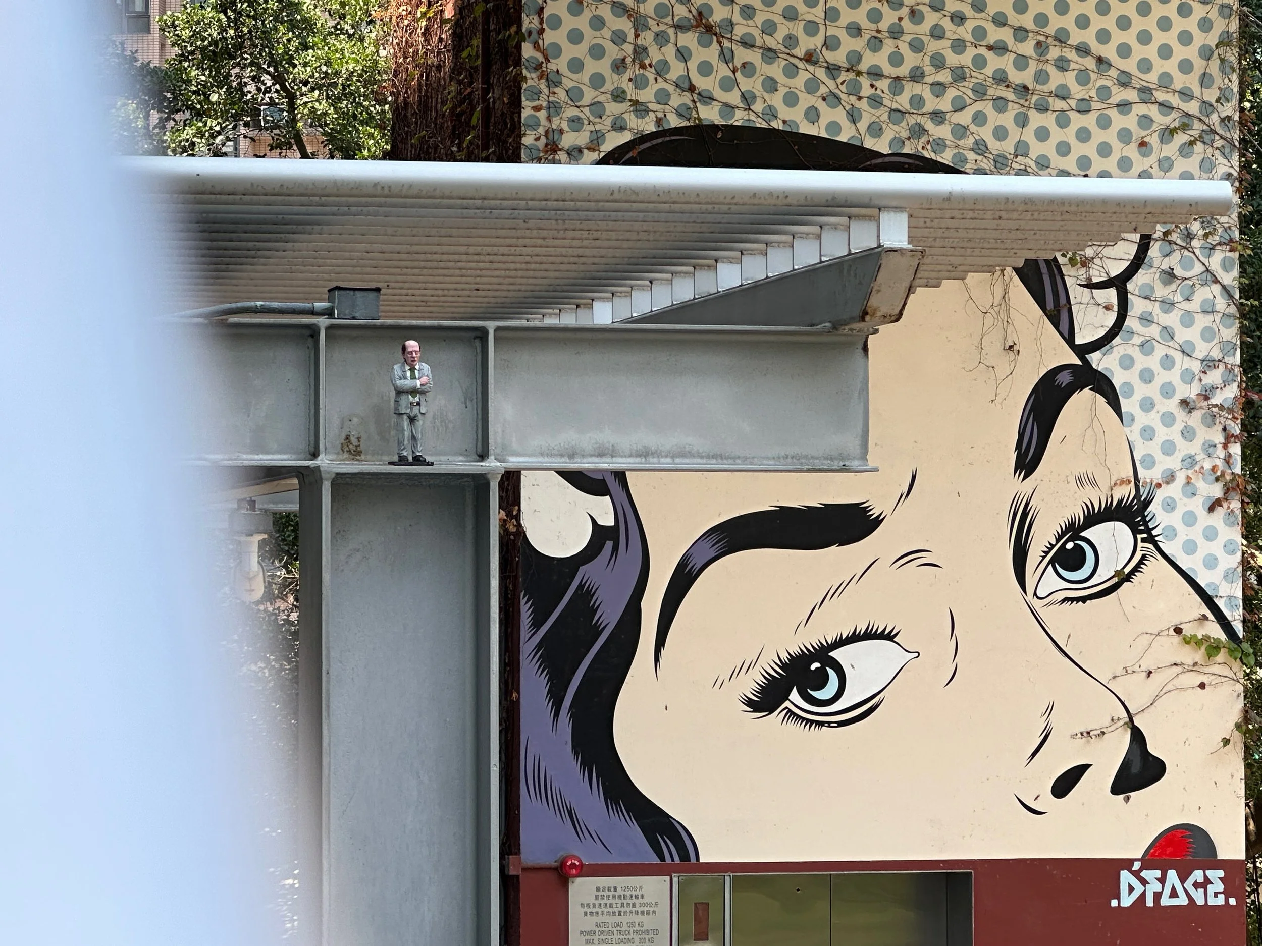 One of Isaac Cordal's mini sculptures and D*Face's 'Sweet Nothings' mural at PMQ