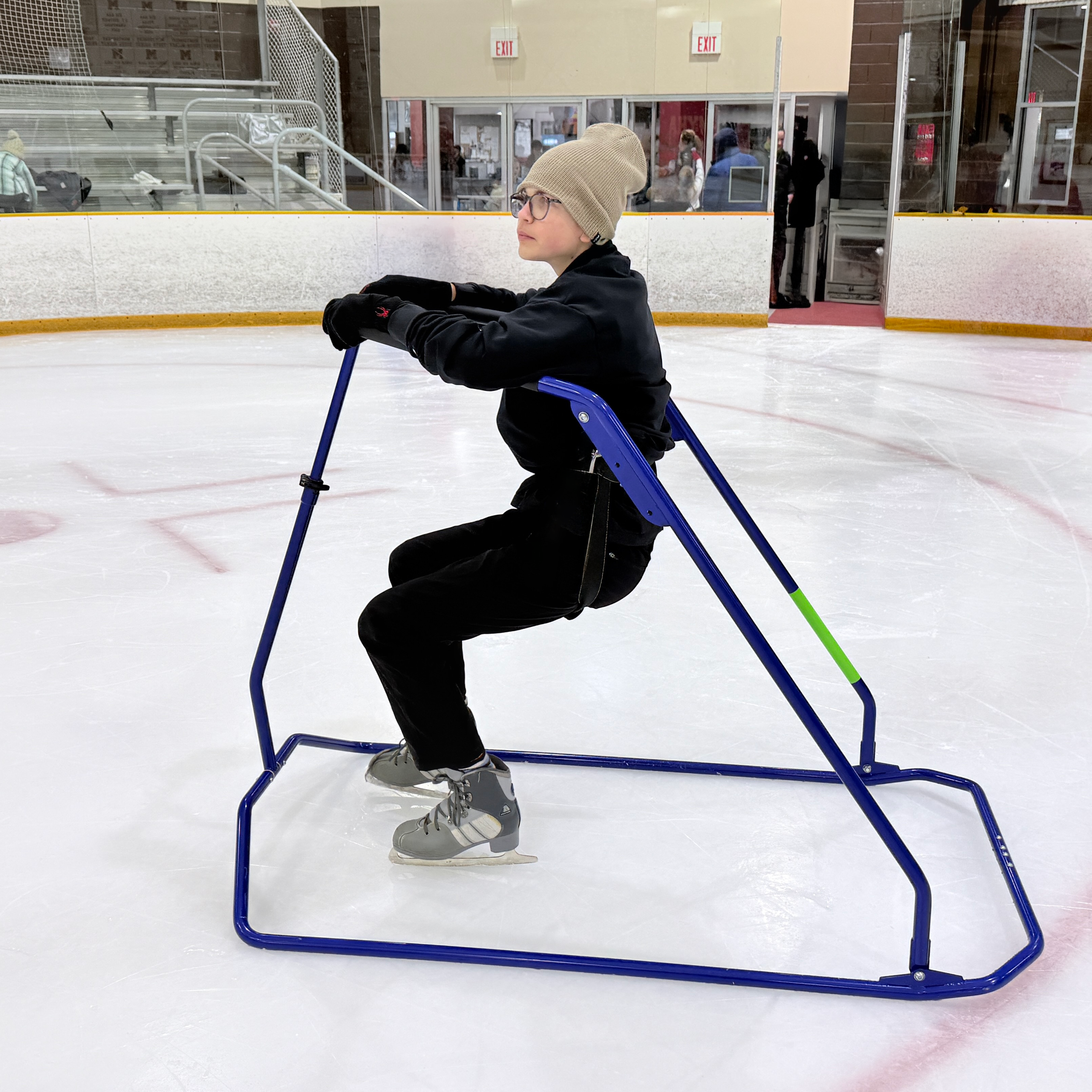 young boy harnessed on ice skating wlaker