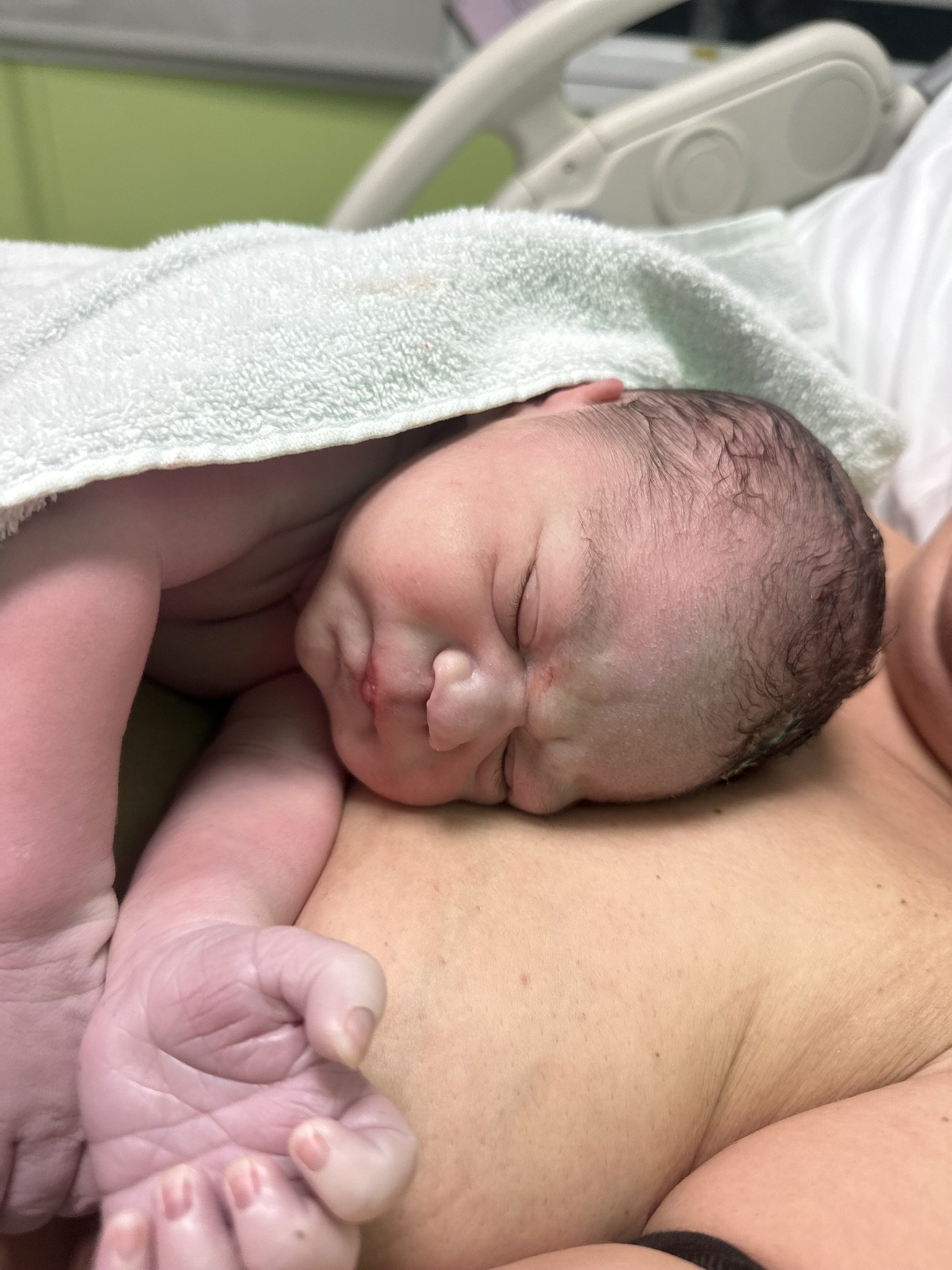 A newborn having skin to skin with mum which helps to regulate heartbeat and temperature
