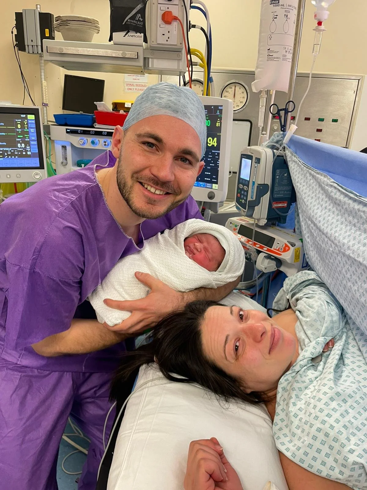 A cesarean section with both happy parents and a newborn