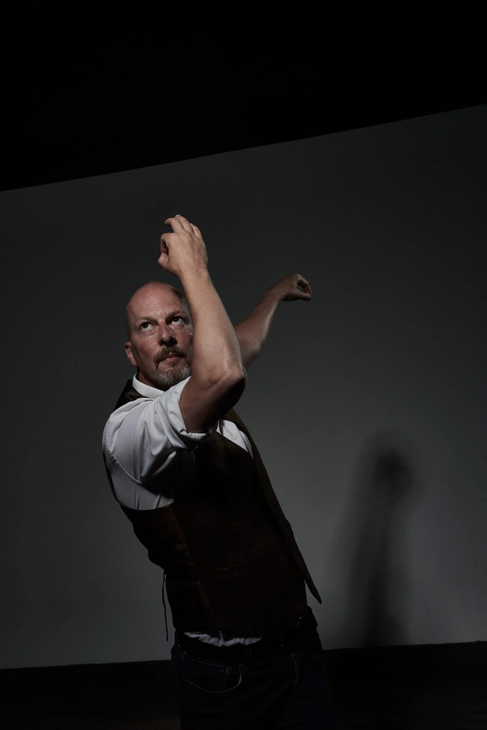 John Darvell performing expressive contemporary dance movement under dramatic stage lighting for NOCTURN digital dance and performance work.