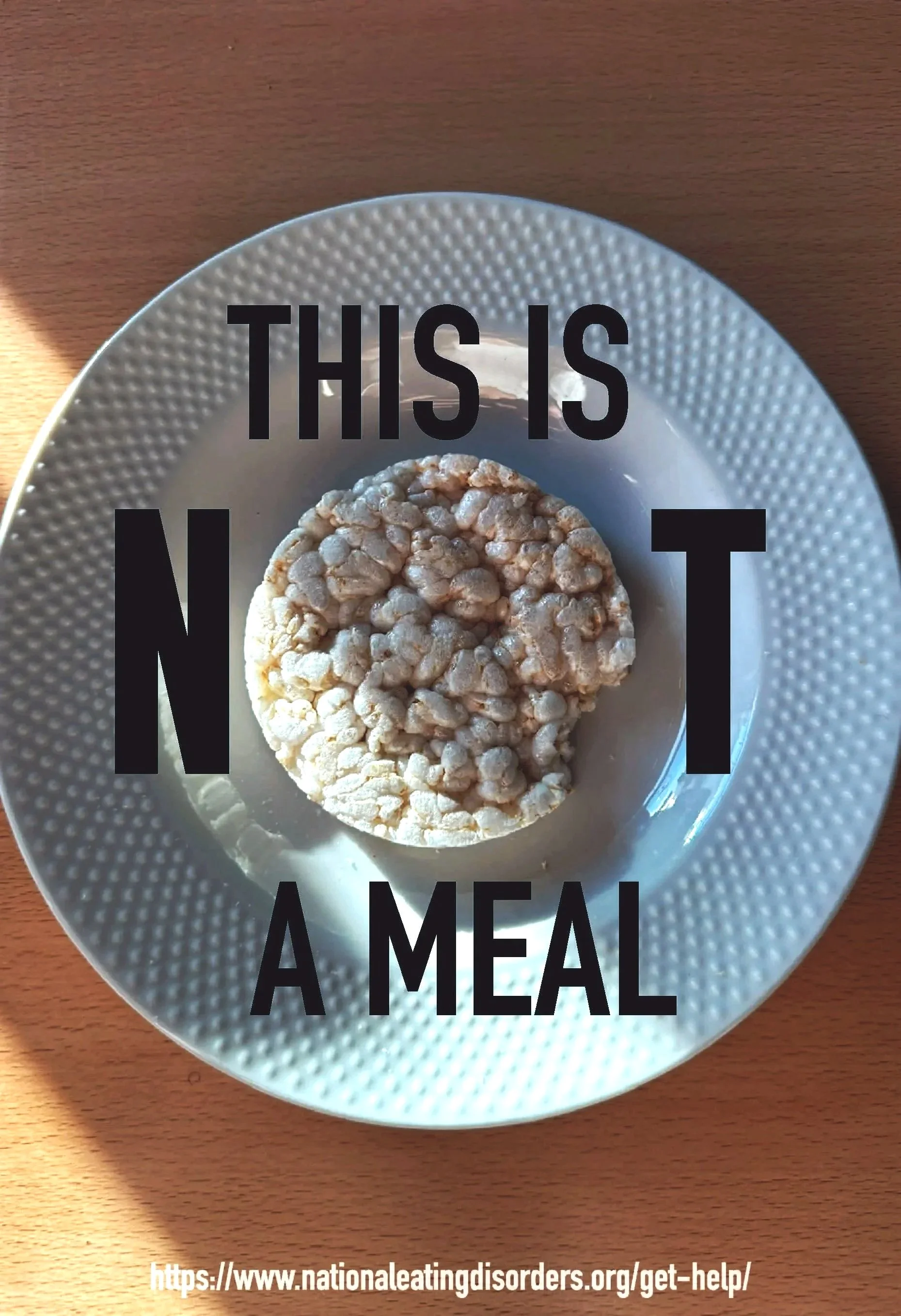 A rice cake on a white plate with black text overlay reading 'This is not a meal' and a URL to a health website.