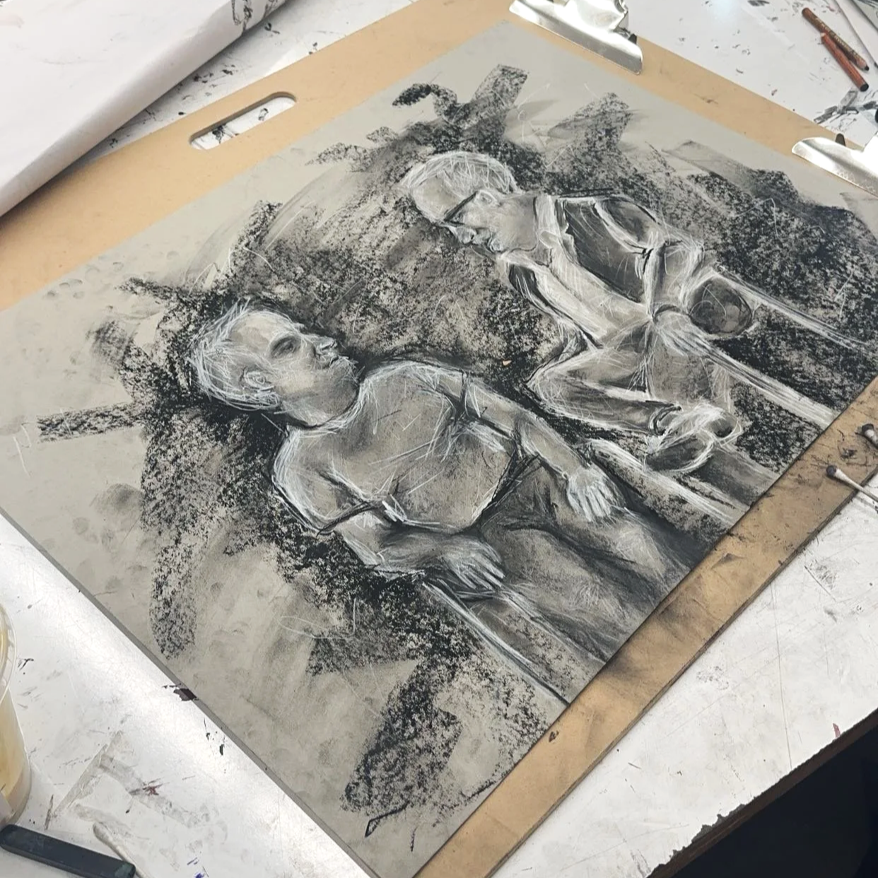 Charcoal drawing of two young boys, one standing and the other sitting, with trees and sky in the background.