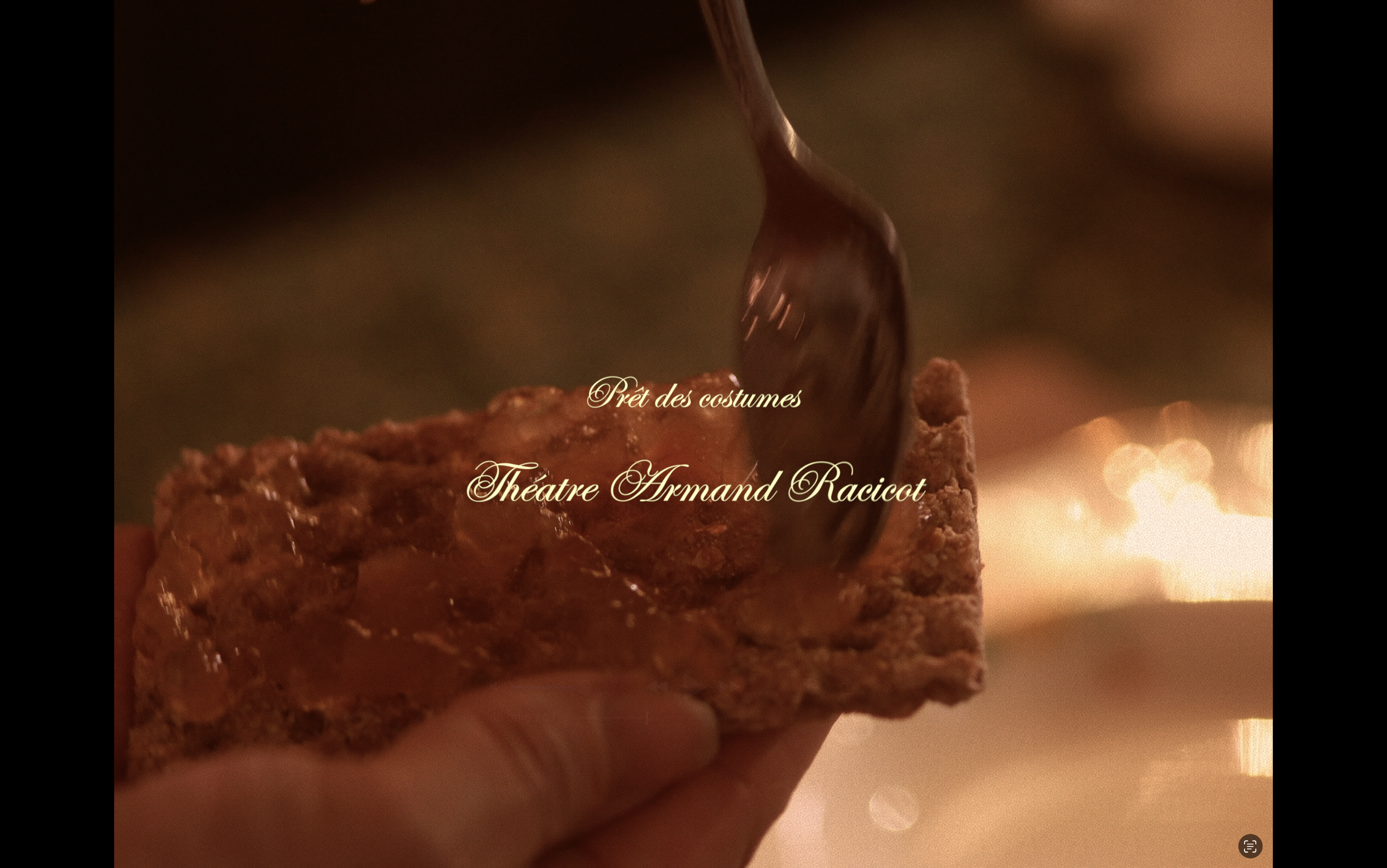 Gâteau avec glaçage au caramel ou à la confiture, une cuillère en train de le recouvrir ou de le traiter, ambiance chaleureuse et éclairage doux, texte en français "Prêt des costumes Théâtre Armand Raciot"