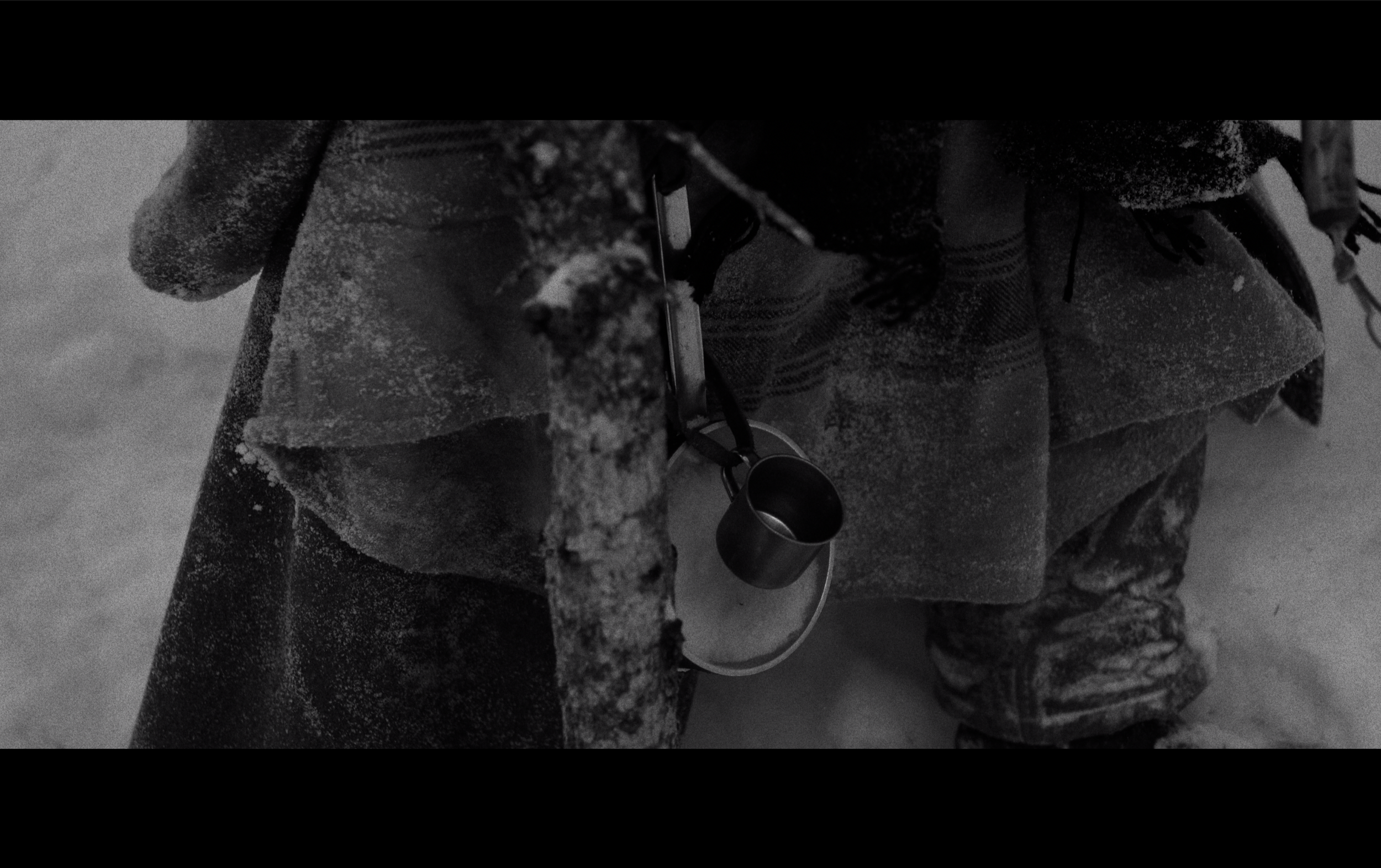 Personnage habillé chaudement en vêtements d'hiver, portant une tasse et un bol suspendus à un sac ou une ceinture, dans un environnement glacé ou enneigé.