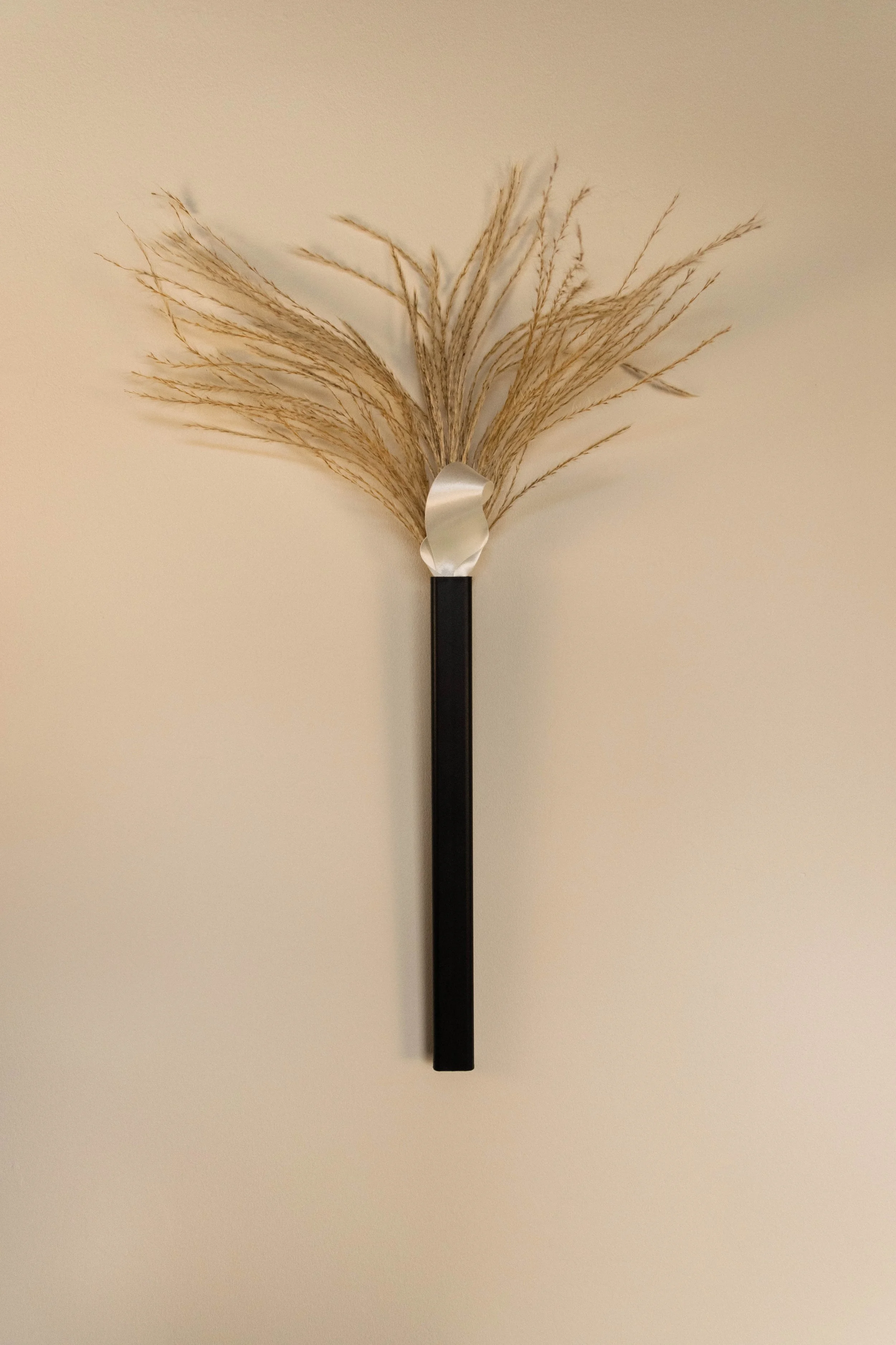 Wall vase art piece with grass in Reflections Office