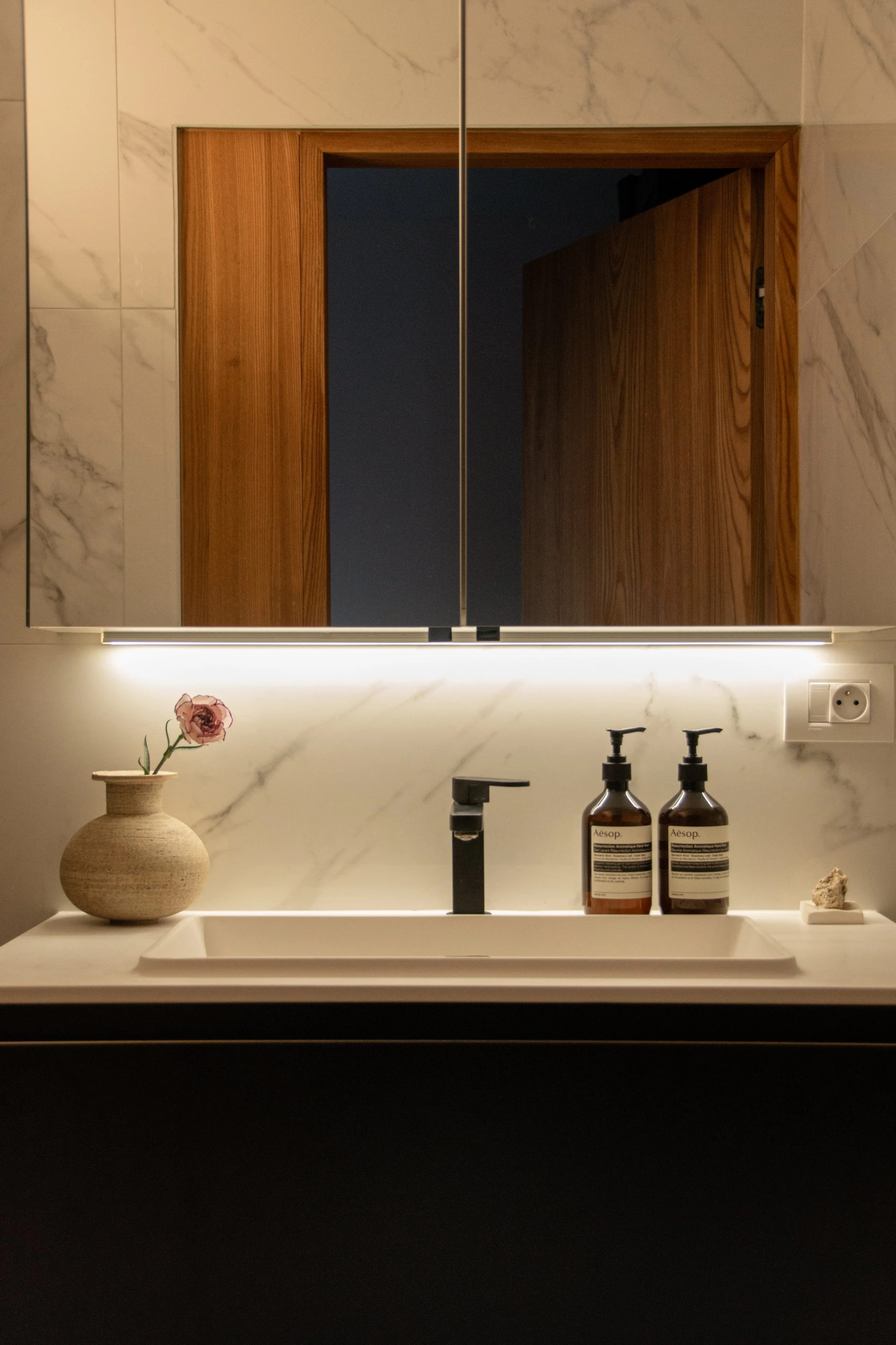 Contemporary bathroom with marble surfaces, warm oak detailing and minimal styling
