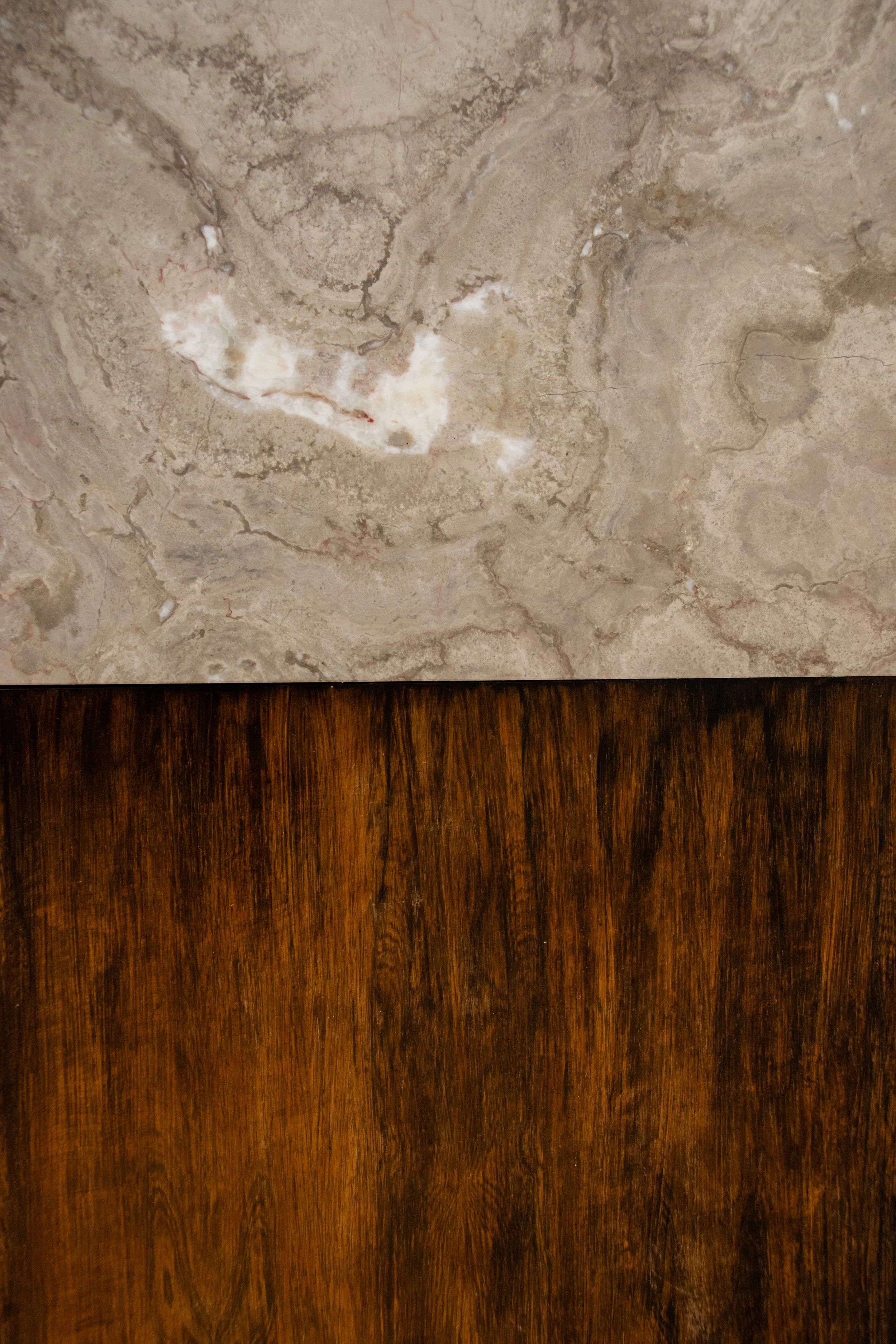 Natural stone and dark wood material composition within contemporary apartment interior