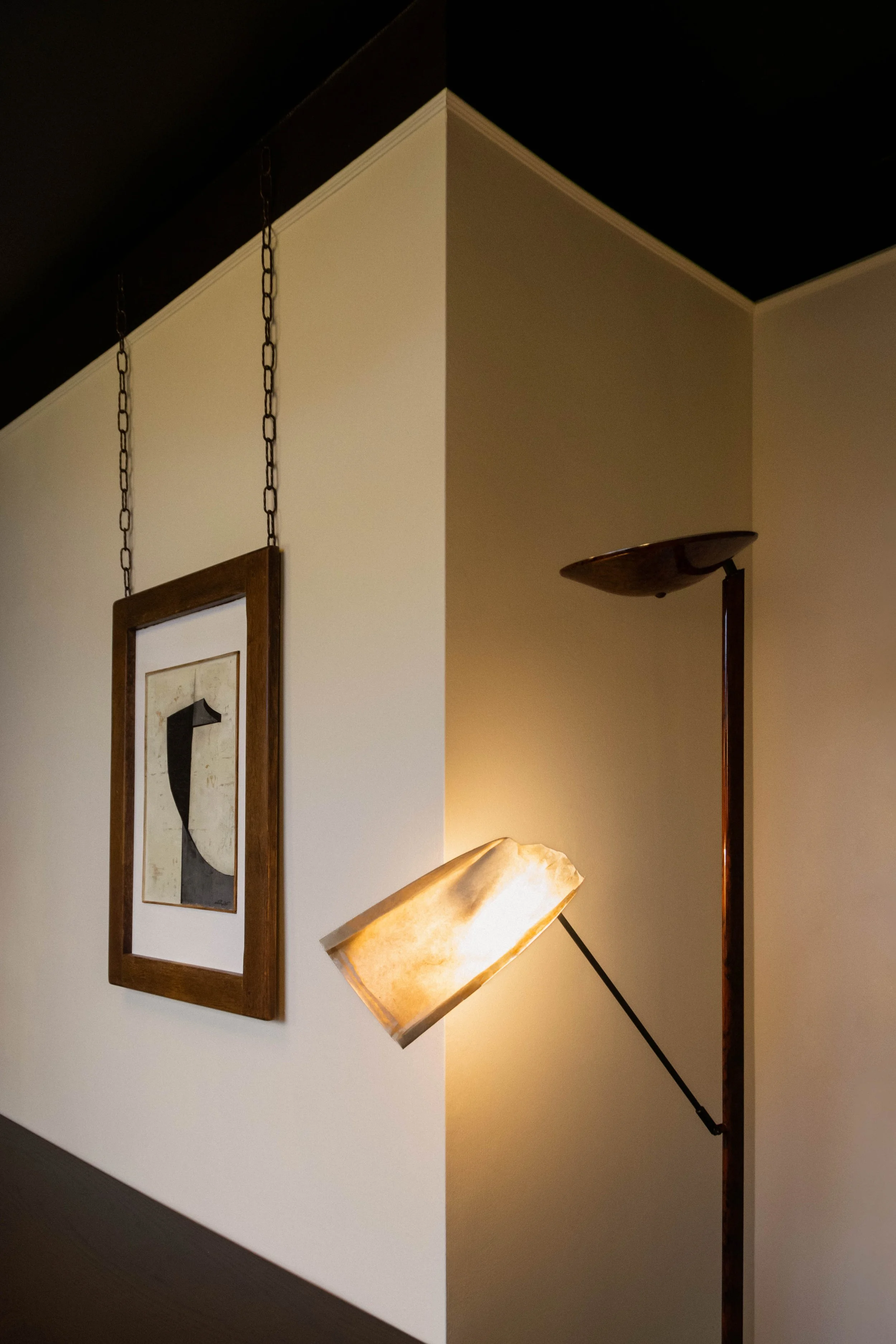 Abstract artwork suspended from the ceiling on metal chains in the Reflections Office