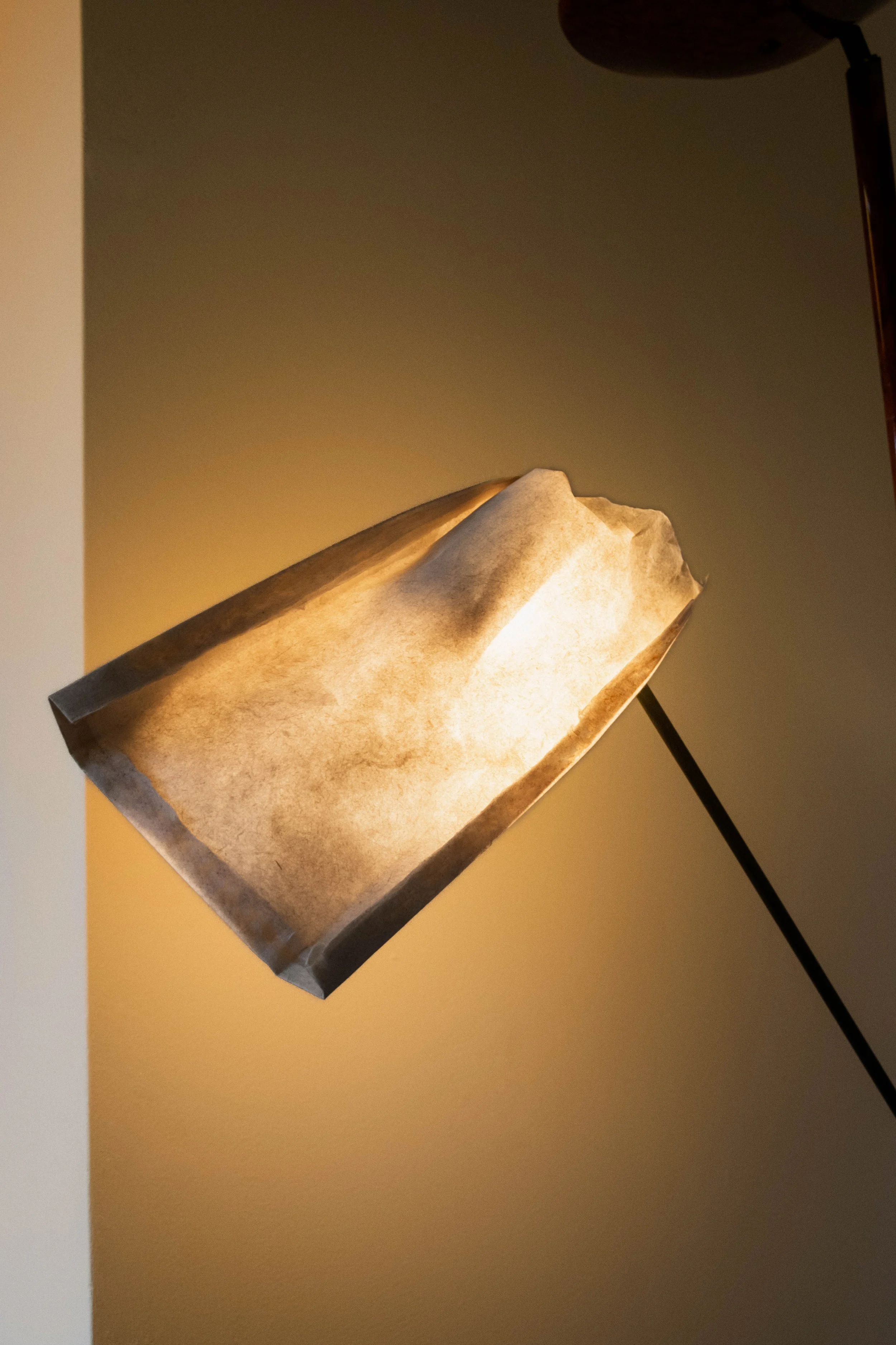 Paper lamp casting a warm glow against off-white walls in the Reflections Office