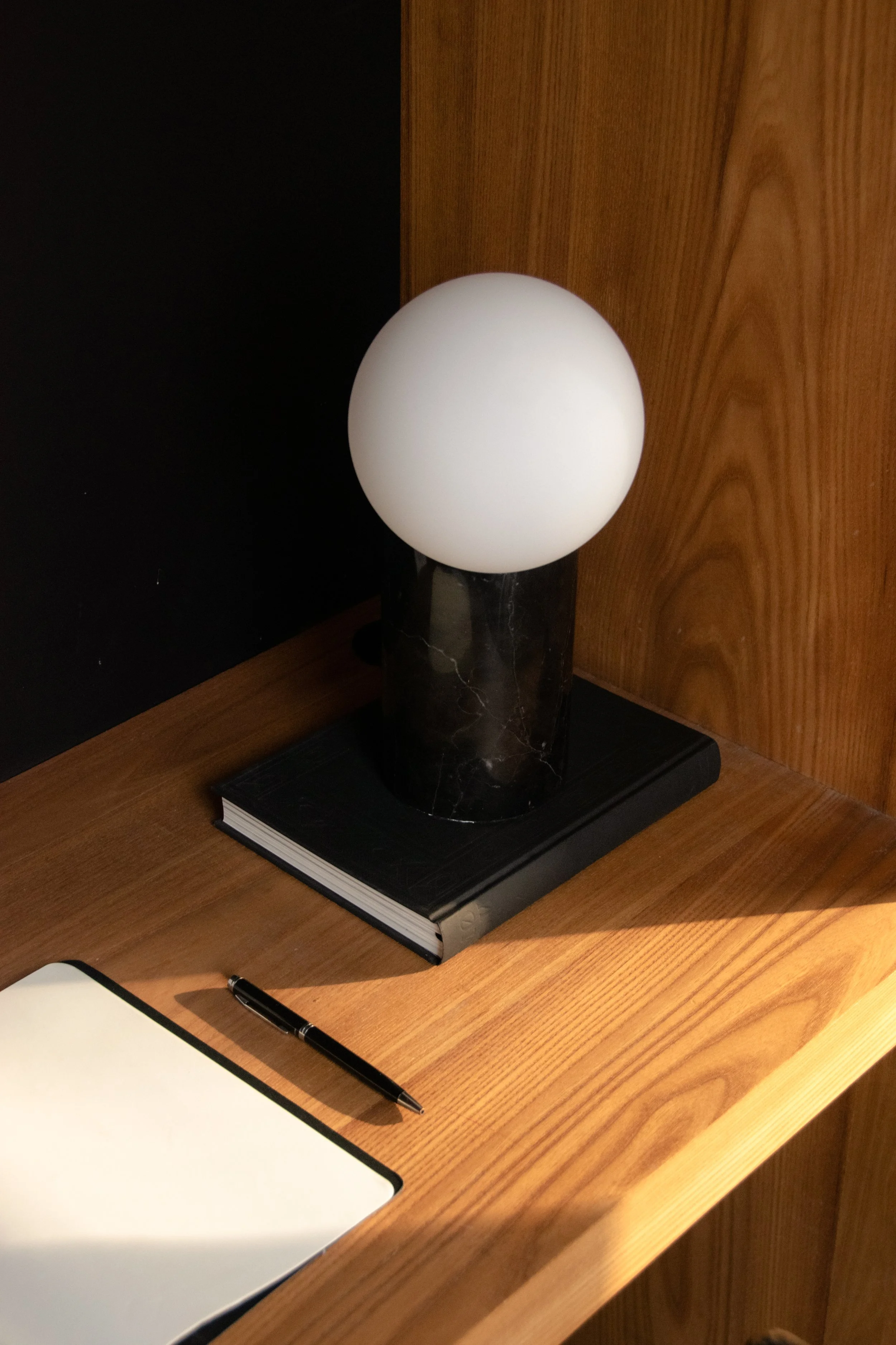 Marble table lamp and workspace styling detail with oak joinery and dark accents